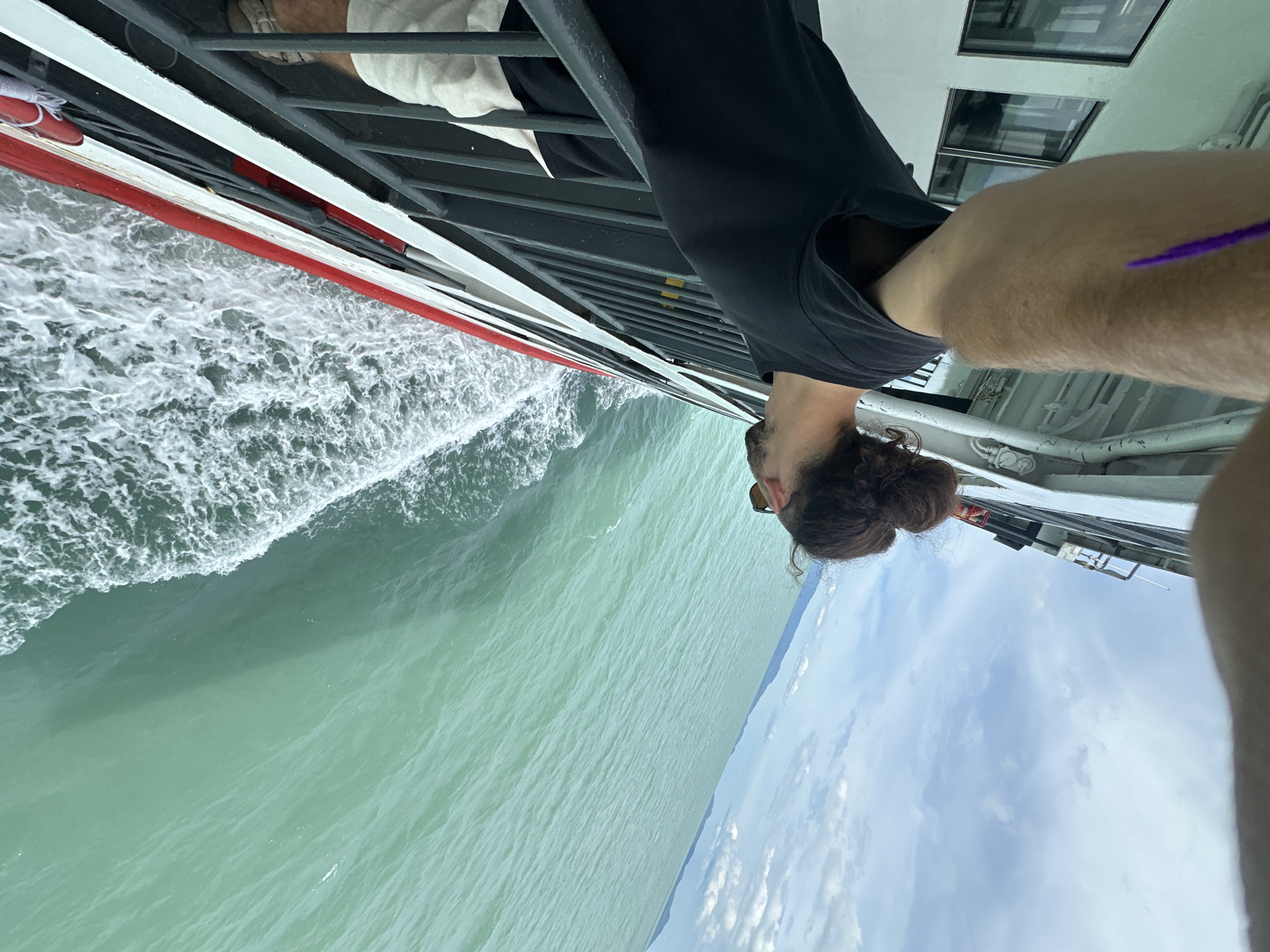 Leaning over a ferry railing in turquoise Thai waters