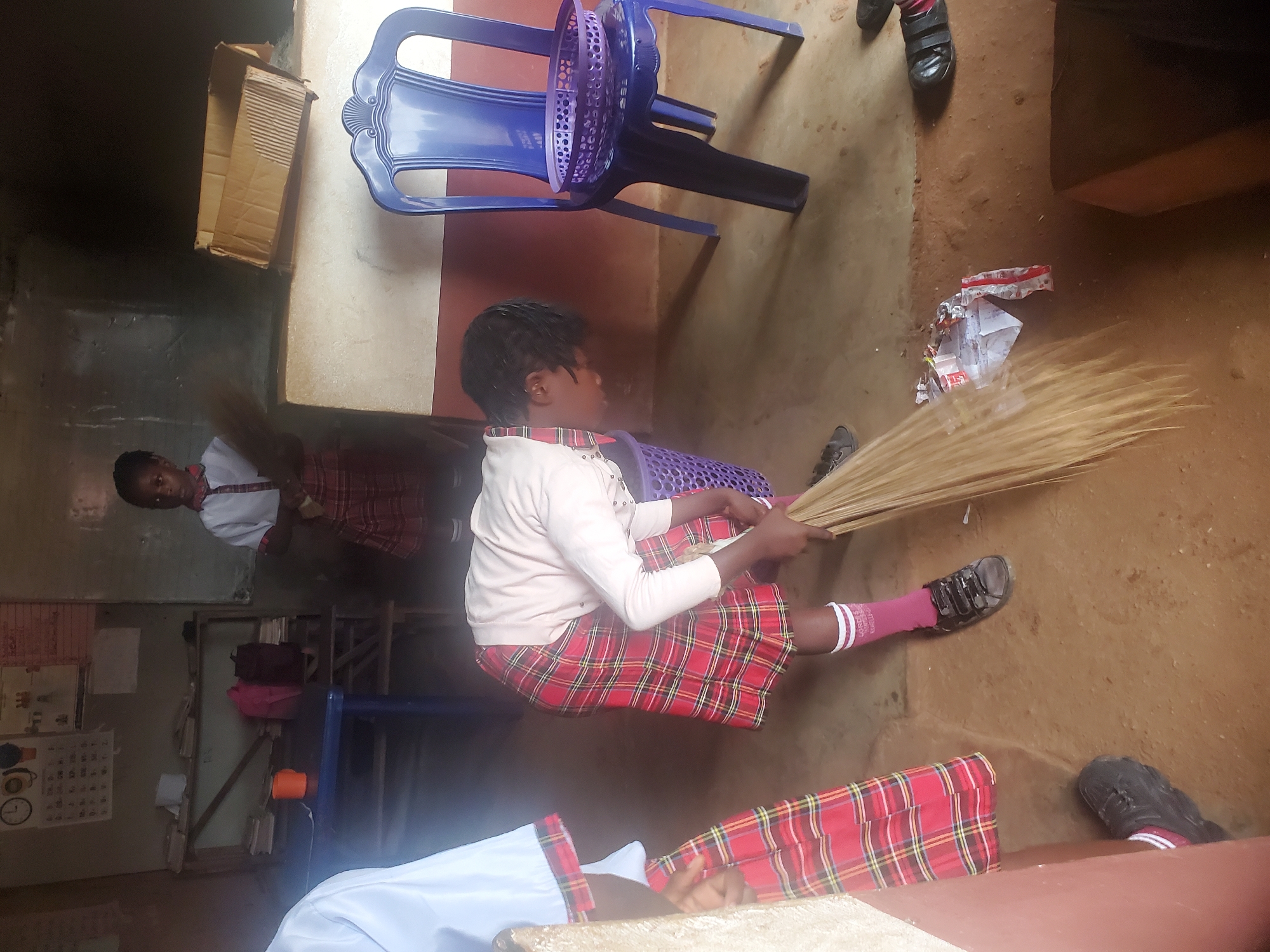 Young person sits with sticks in Ukwu-Abwa, Nigeria