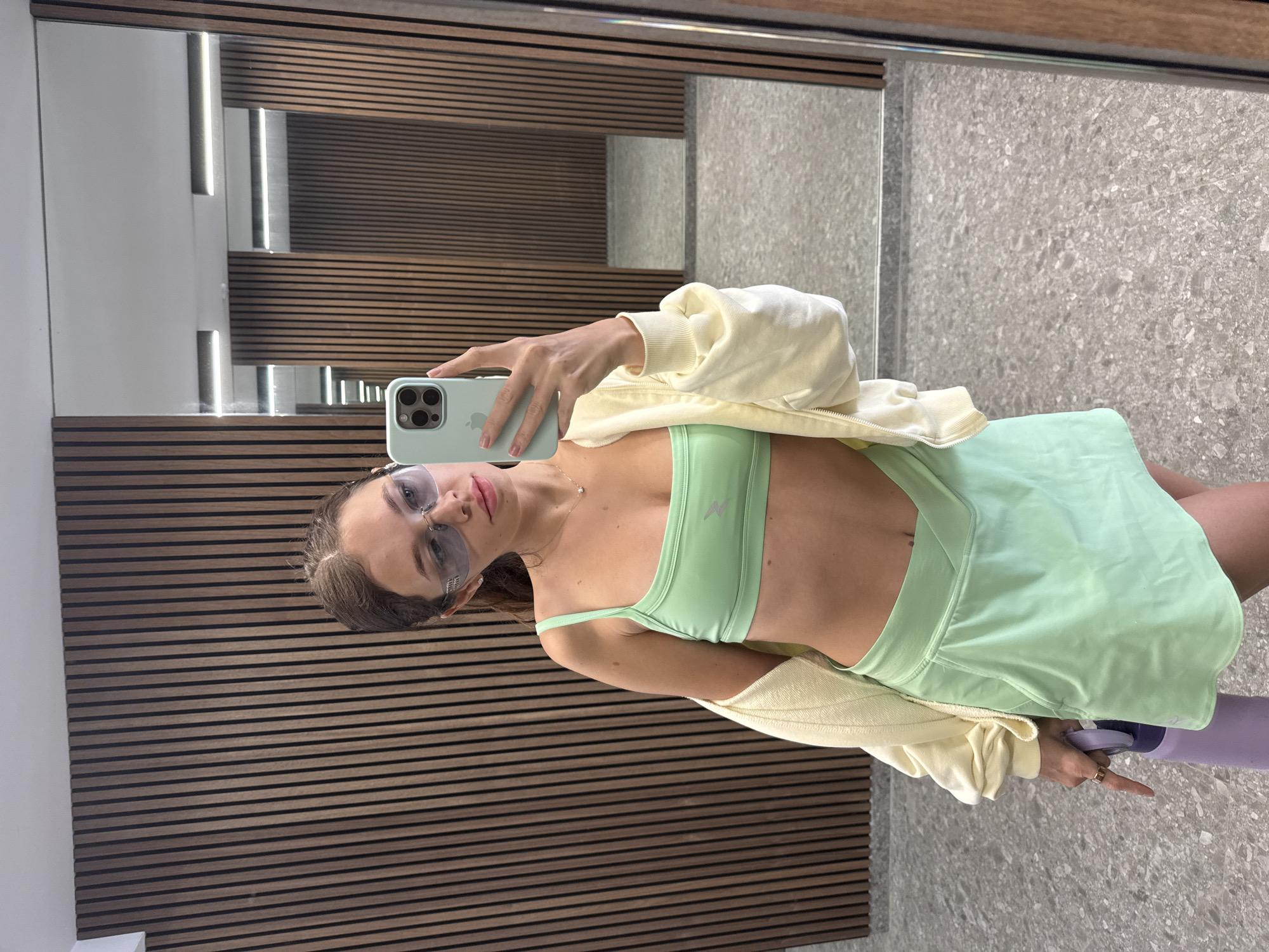 Woman takes mirror selfie at Cyprus gym in athletic wear