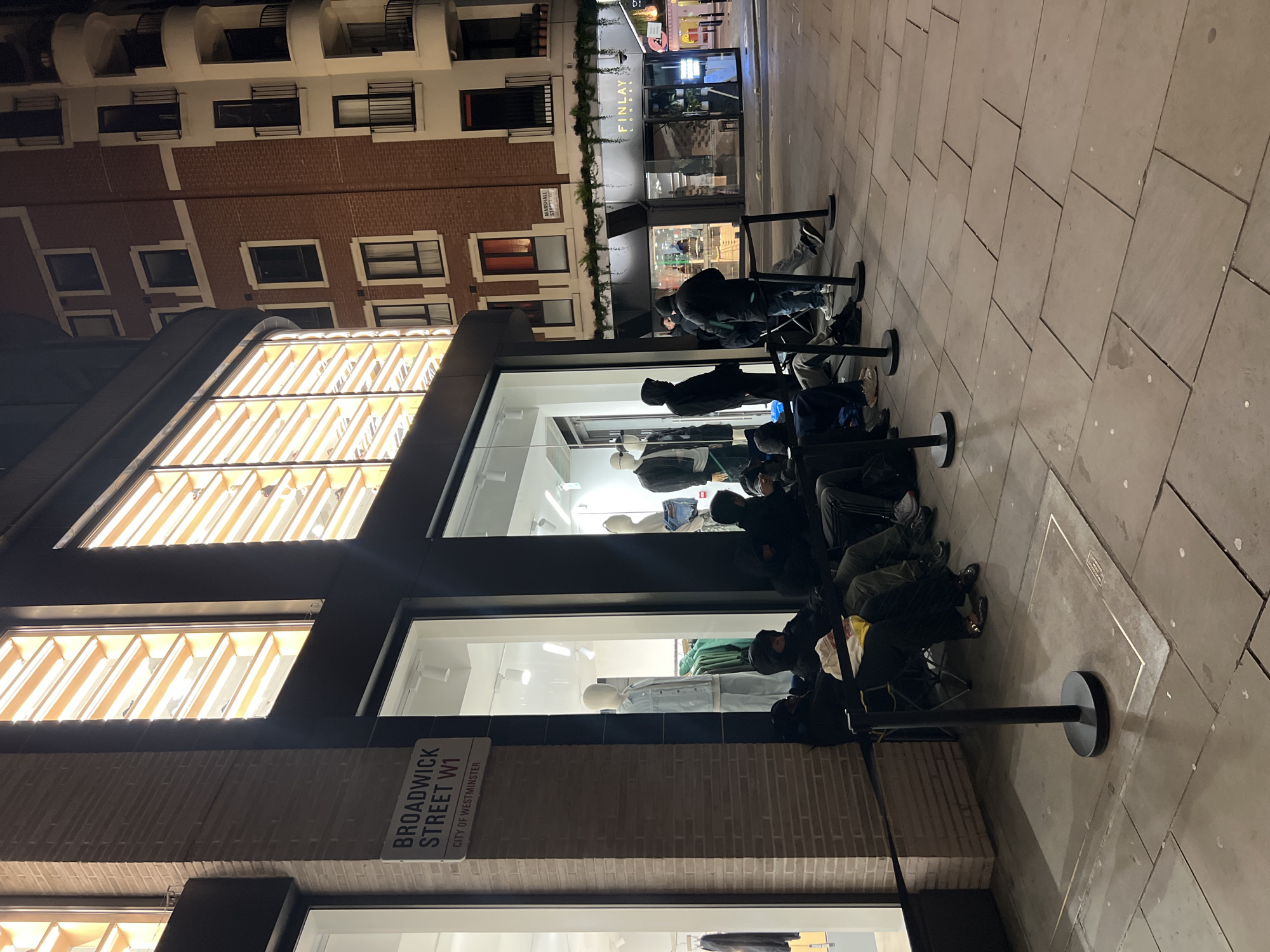 Nighttime queue forms outside London retail store