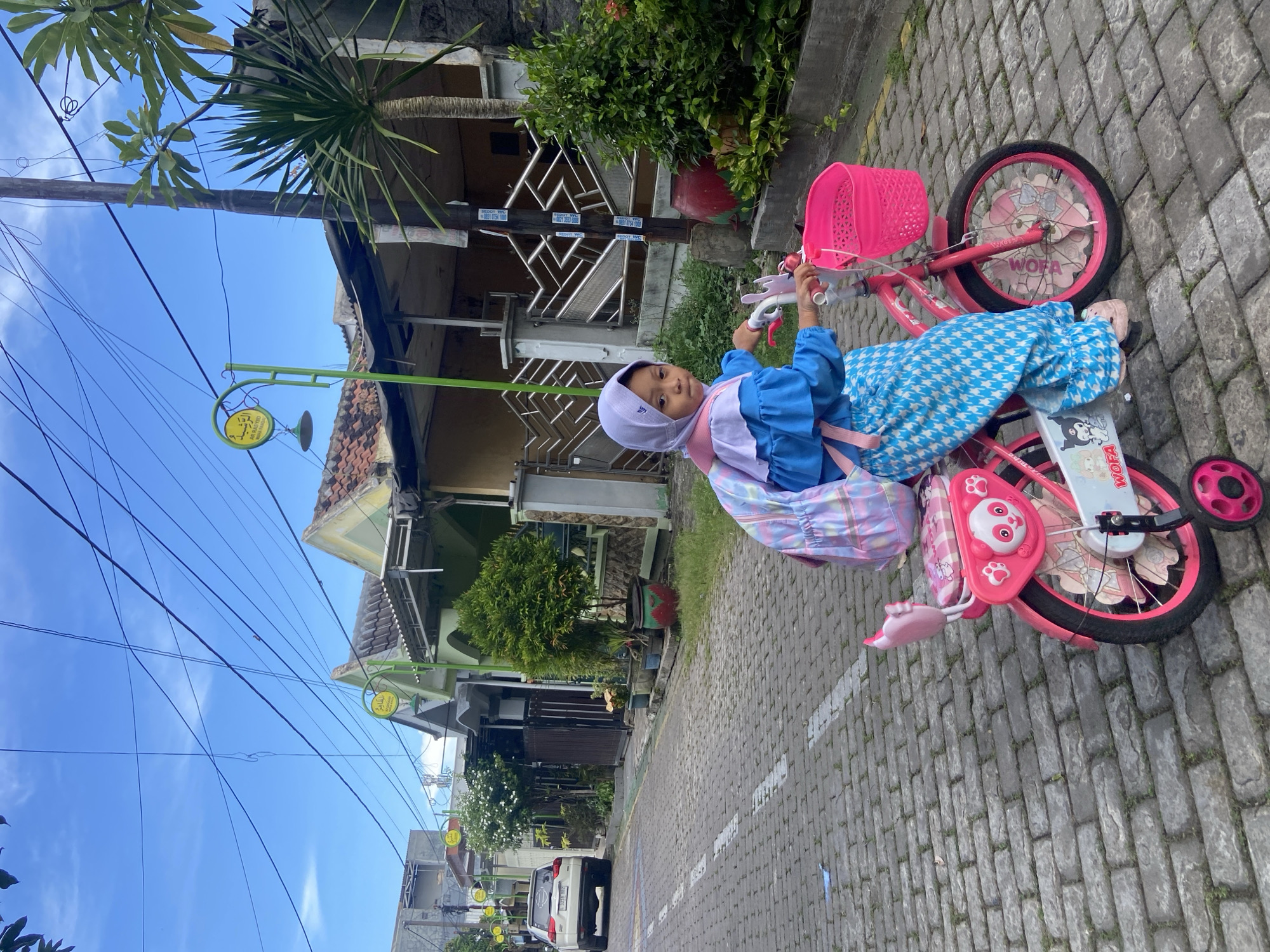 Young girl plays and cycles in Gelam, Indonesia