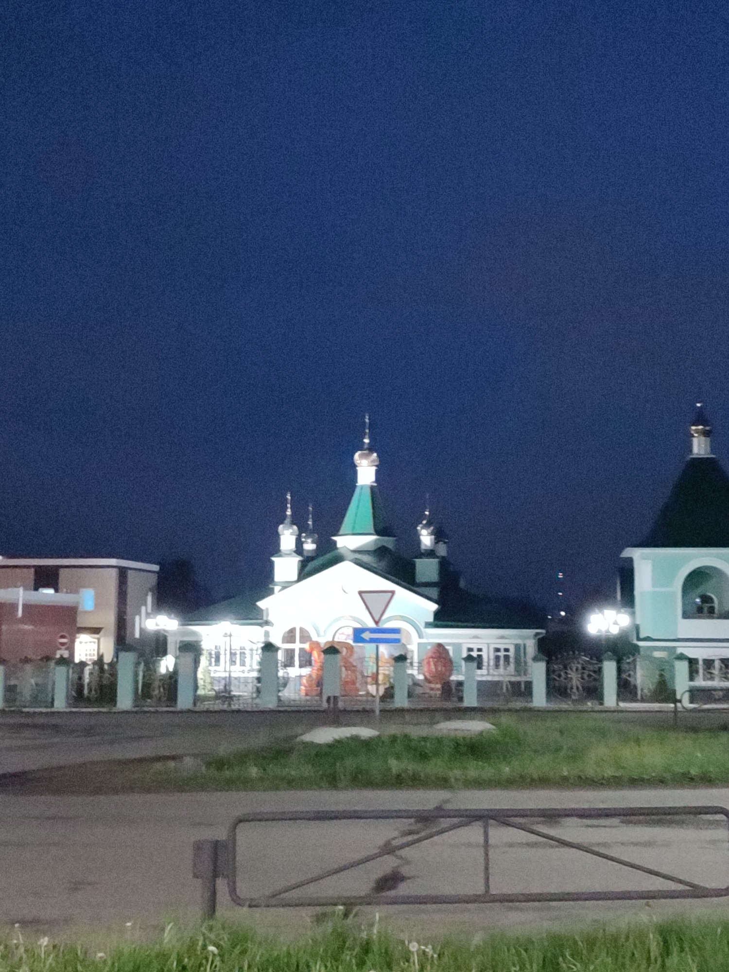 Orthodox church and carved wooden figure documented at night