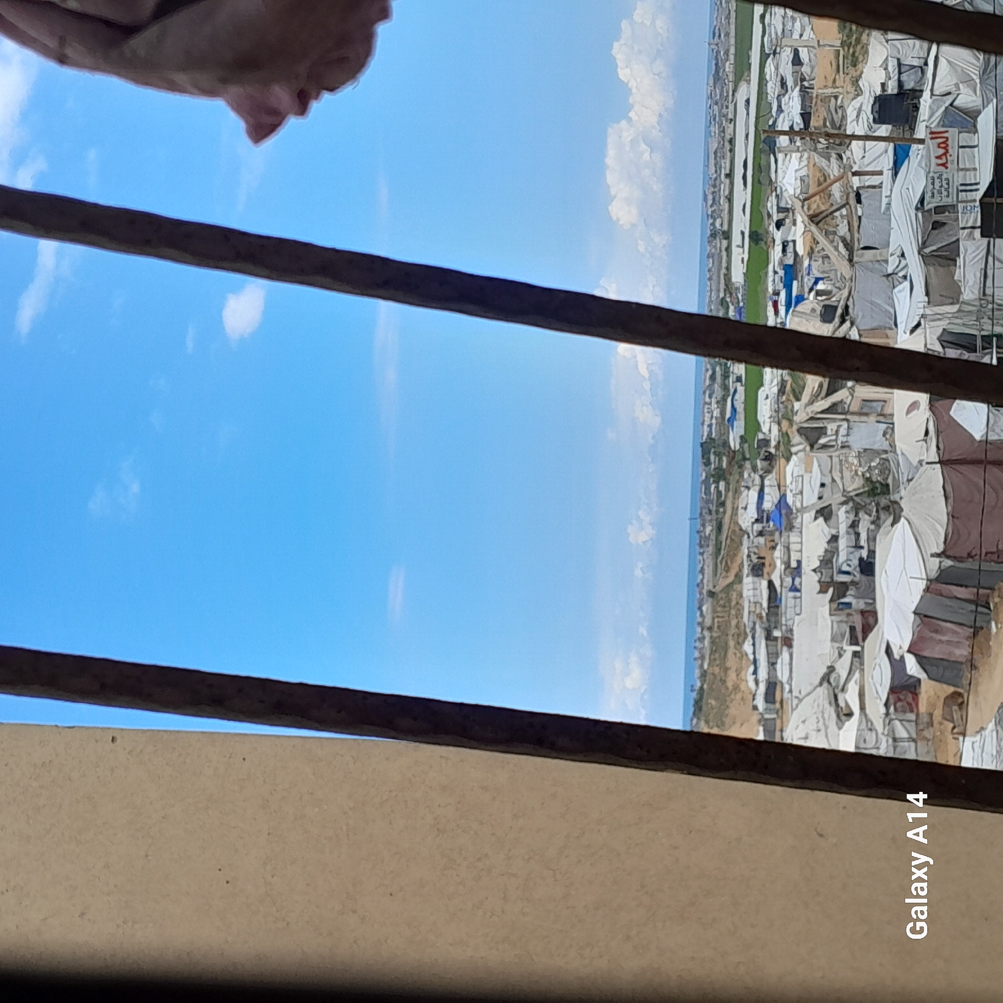 Witnesses document refugee camp scenes from elevated urban positions