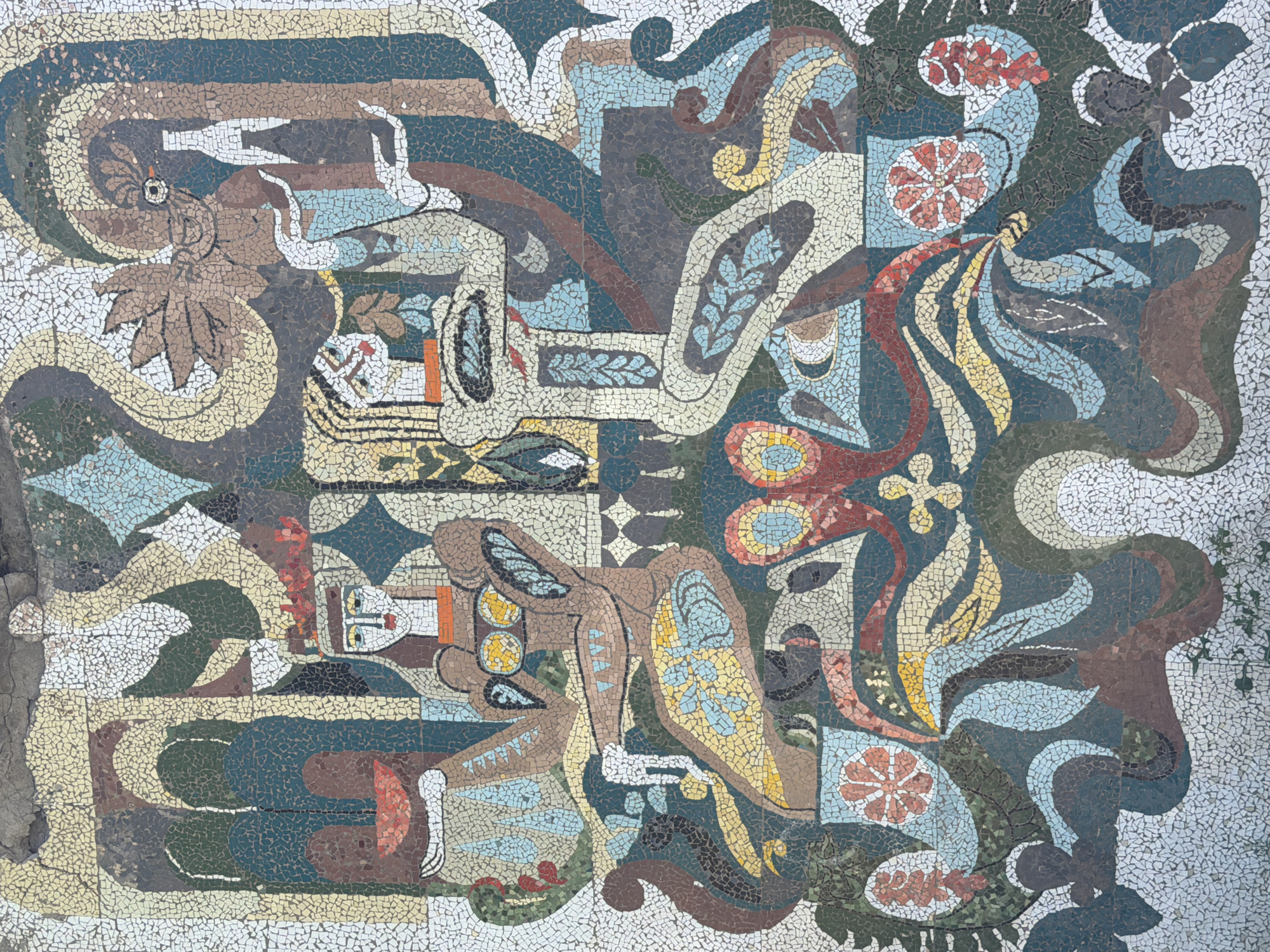 Surreal mosaic mural on a weathered building in Surami, Georgia