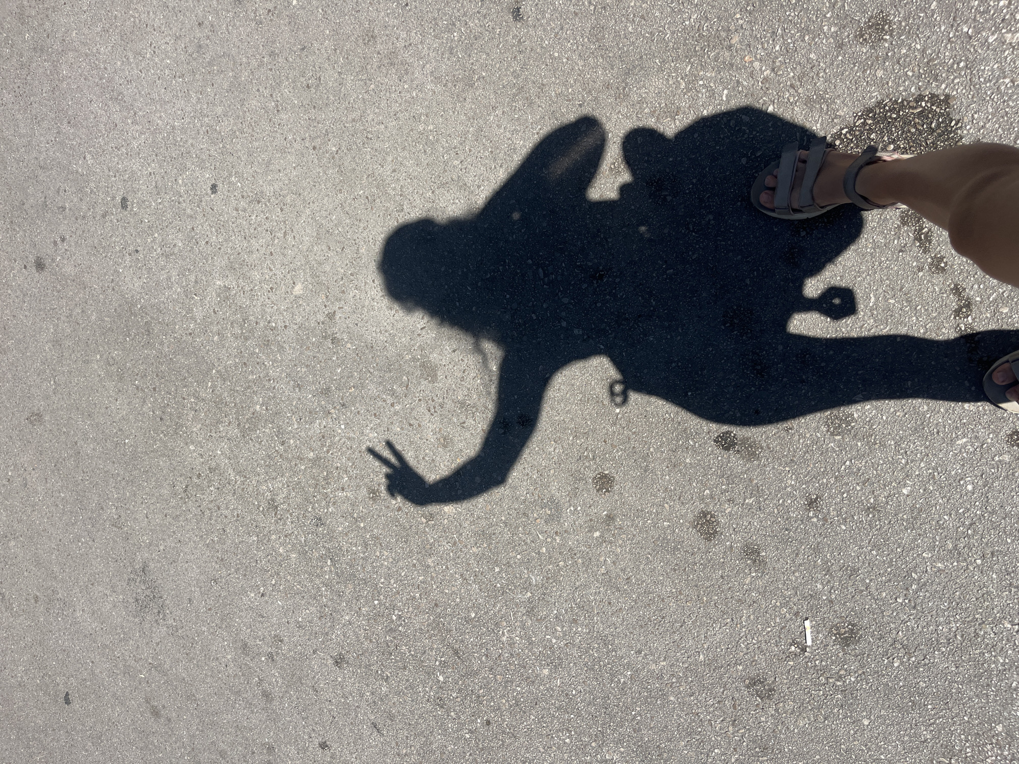 Groceries, a yoga mat, and a peace sign shadow on pavement