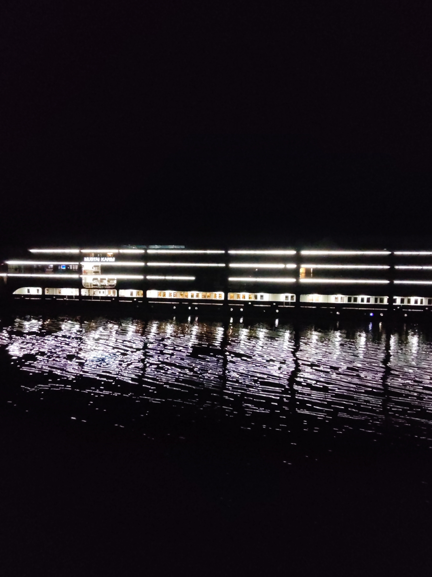 Illuminated passenger ship Mustai Karim observed on dark waters