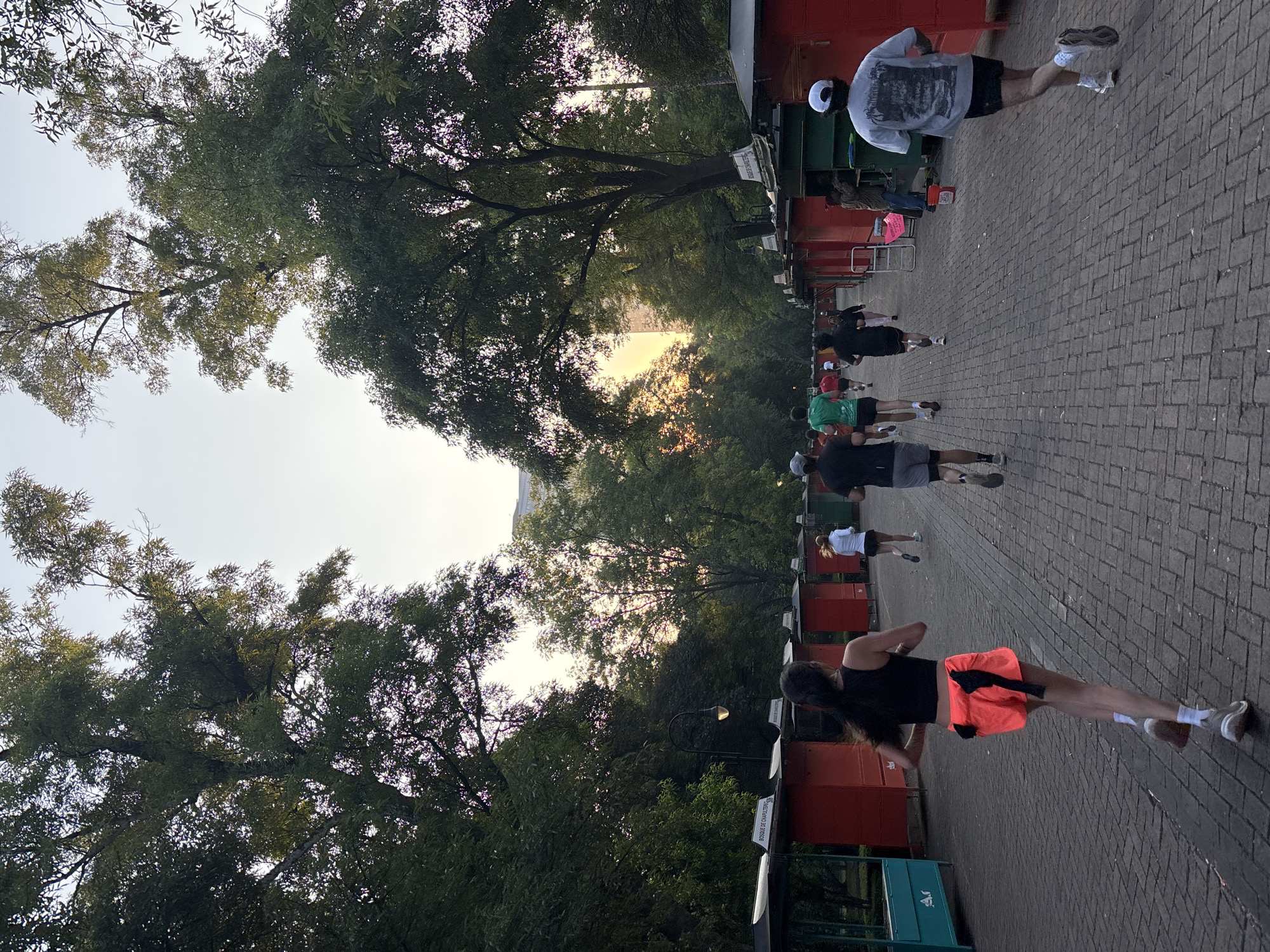 Joggers exercise along tree-lined Mexico City pathways near lake
