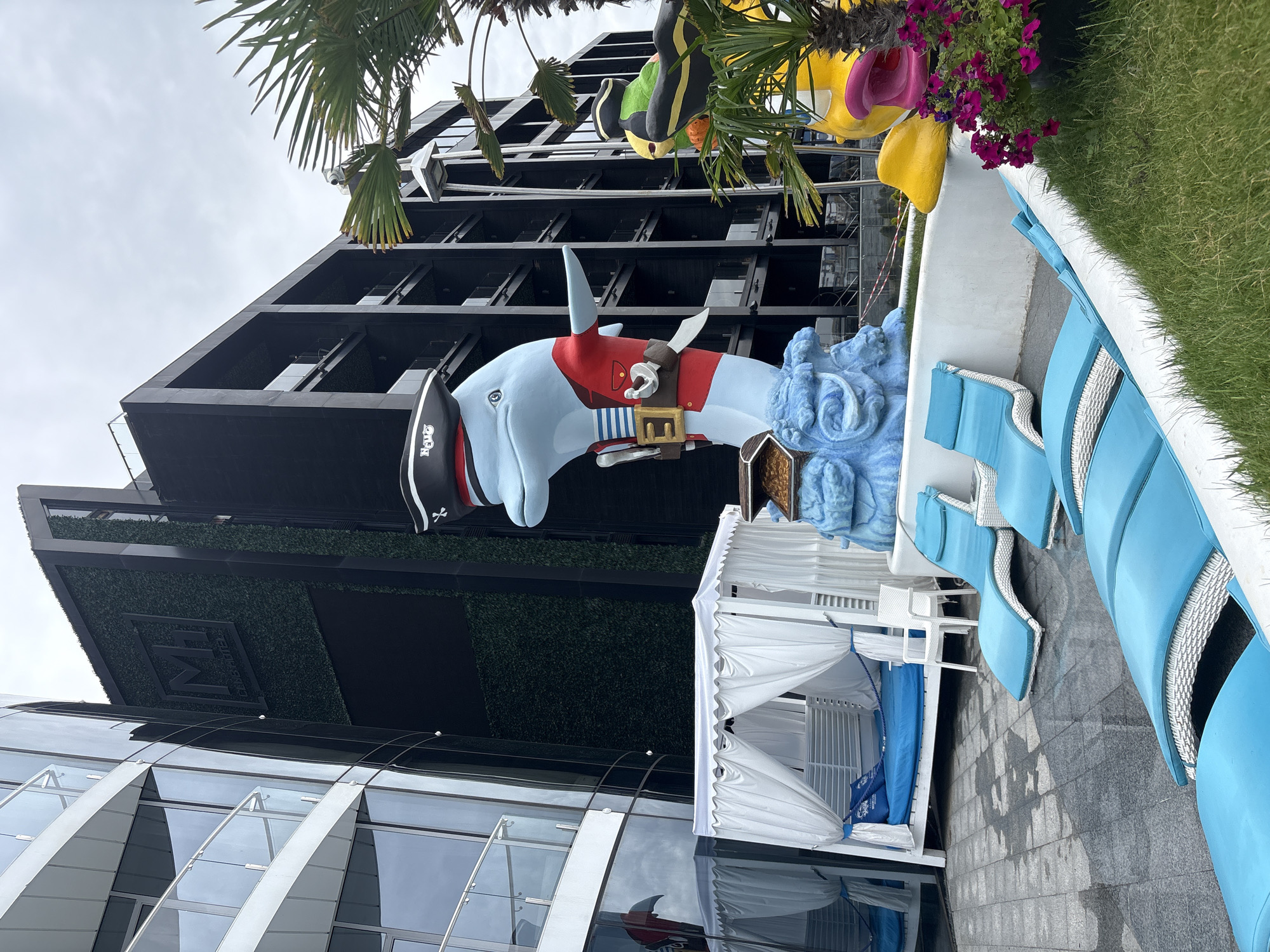 Coastal resort grounds: pier, lounge chairs, and novelty sculpture
