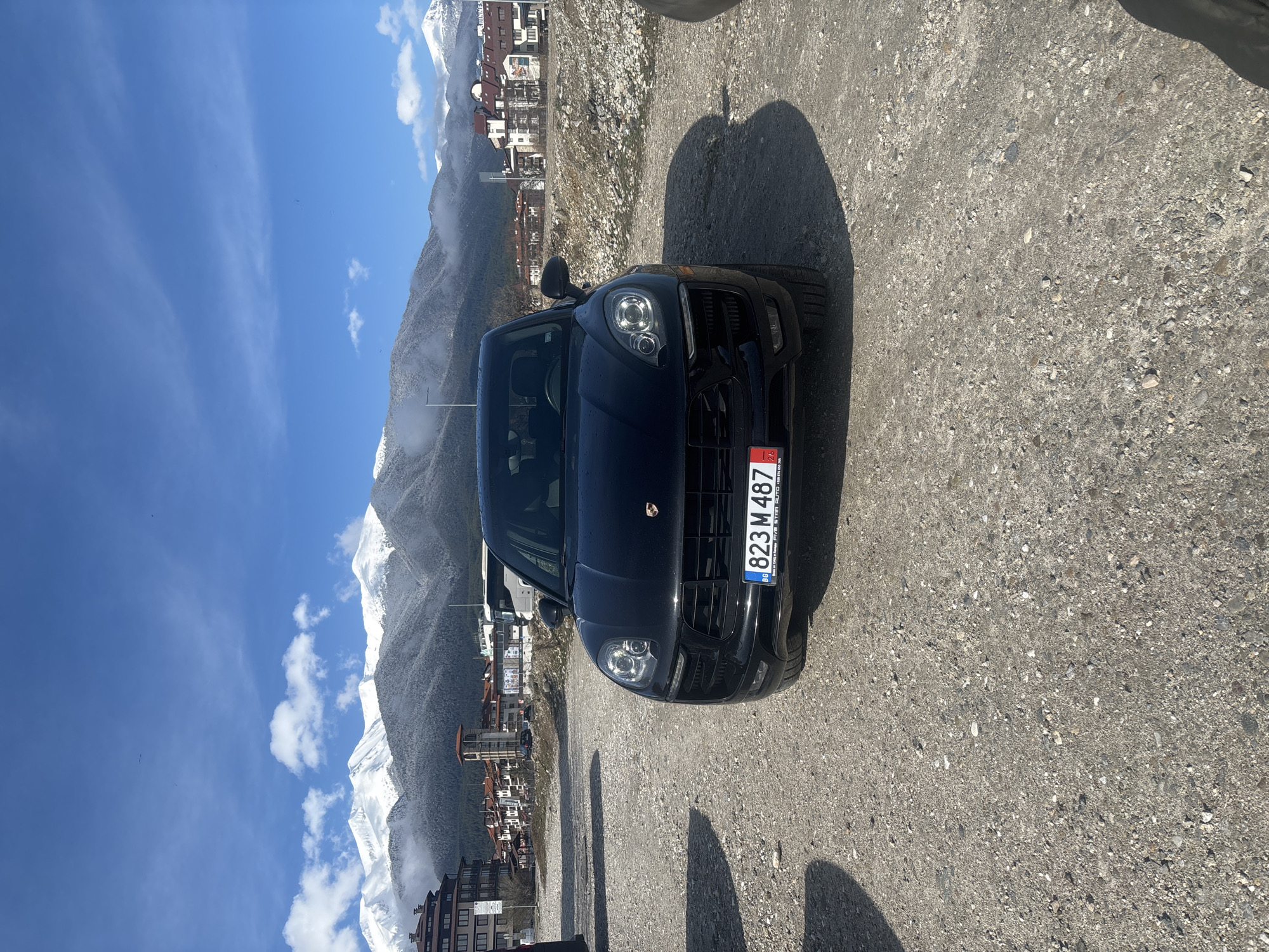 Black Porsche parked on gravel road in Bansko Bulgaria