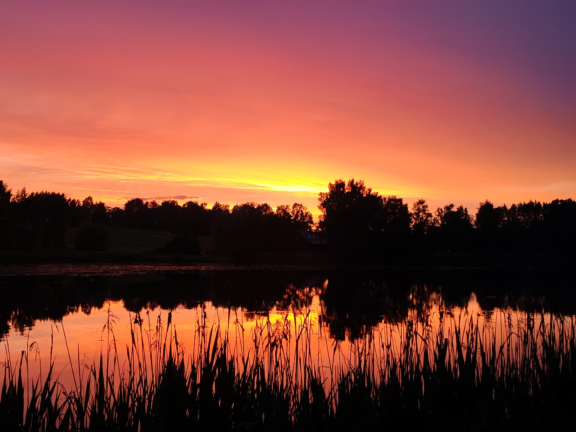 Vibrant sunset documented over lake with colorful sky reflections