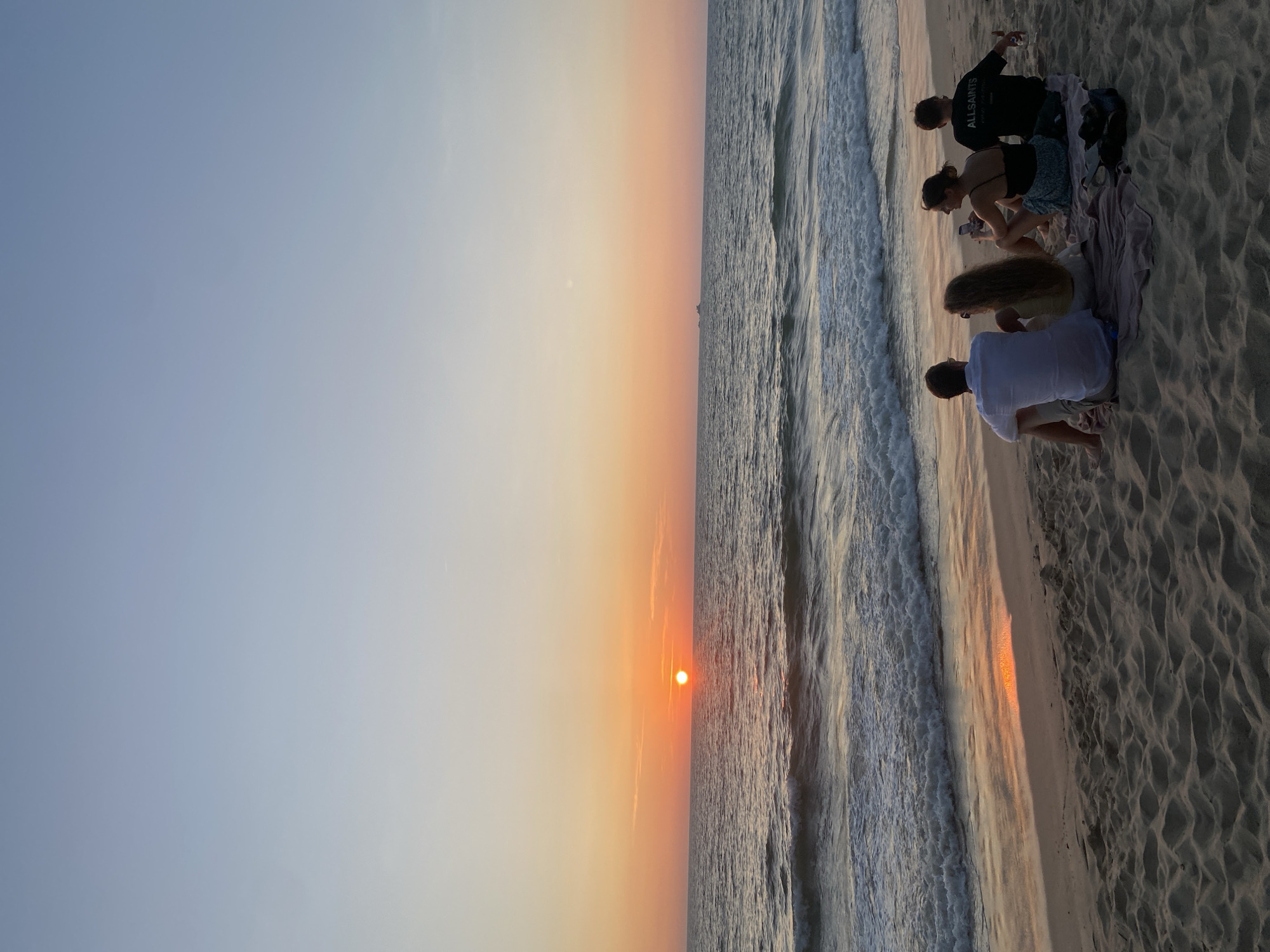 Beachgoers enjoy ocean waves at Choeng Thale, Thailand
