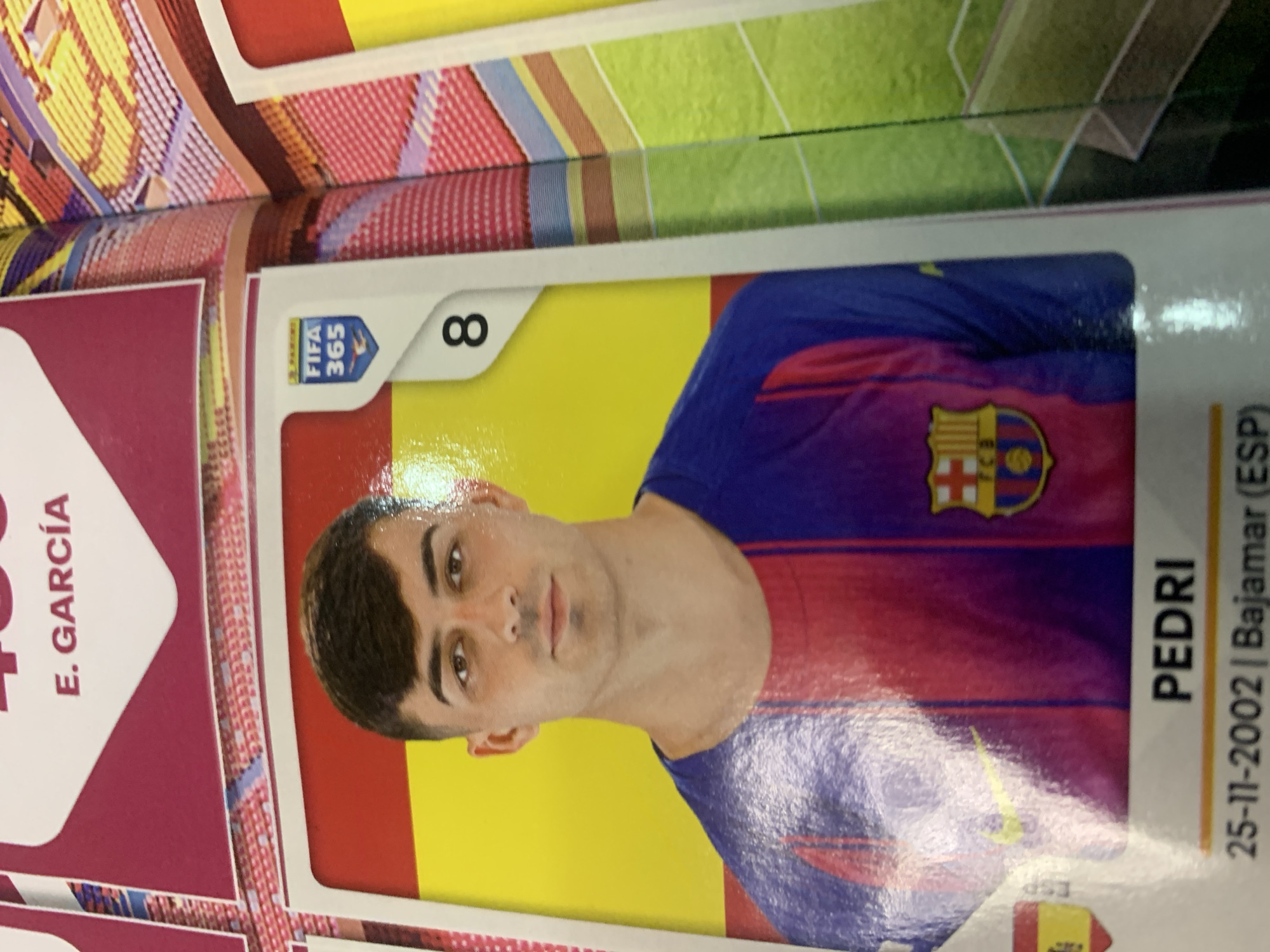 Flipping through a FIFA 365 trading card and sticker collection