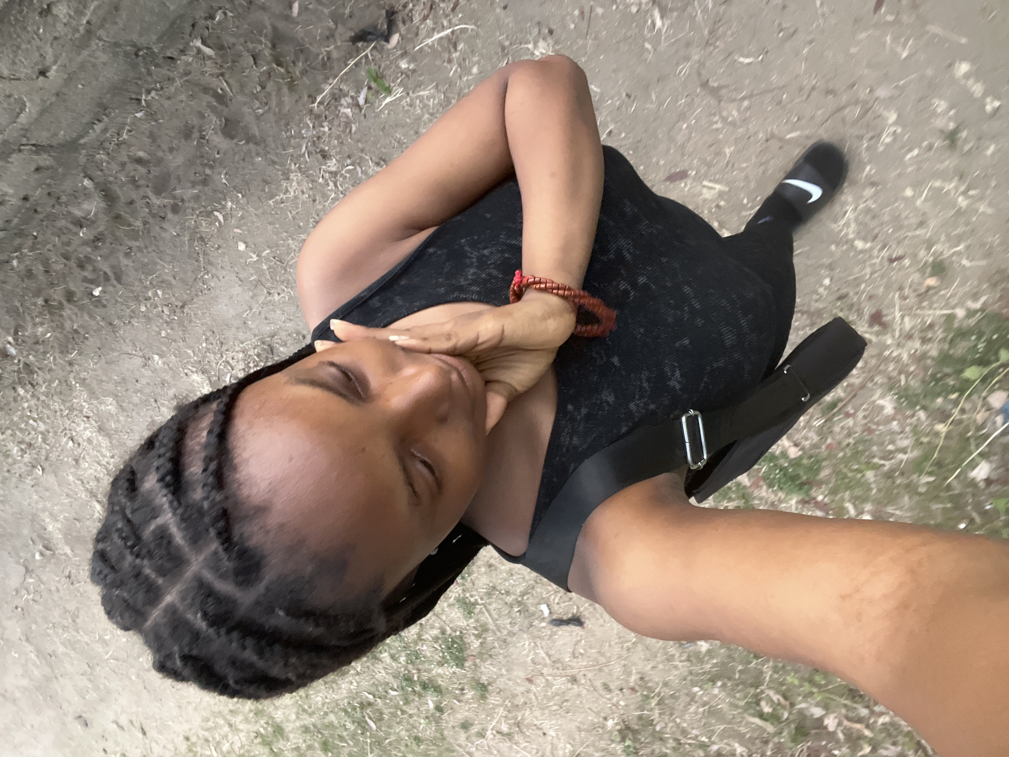 Woman photographed in black outfit on Lokoja dirt path
