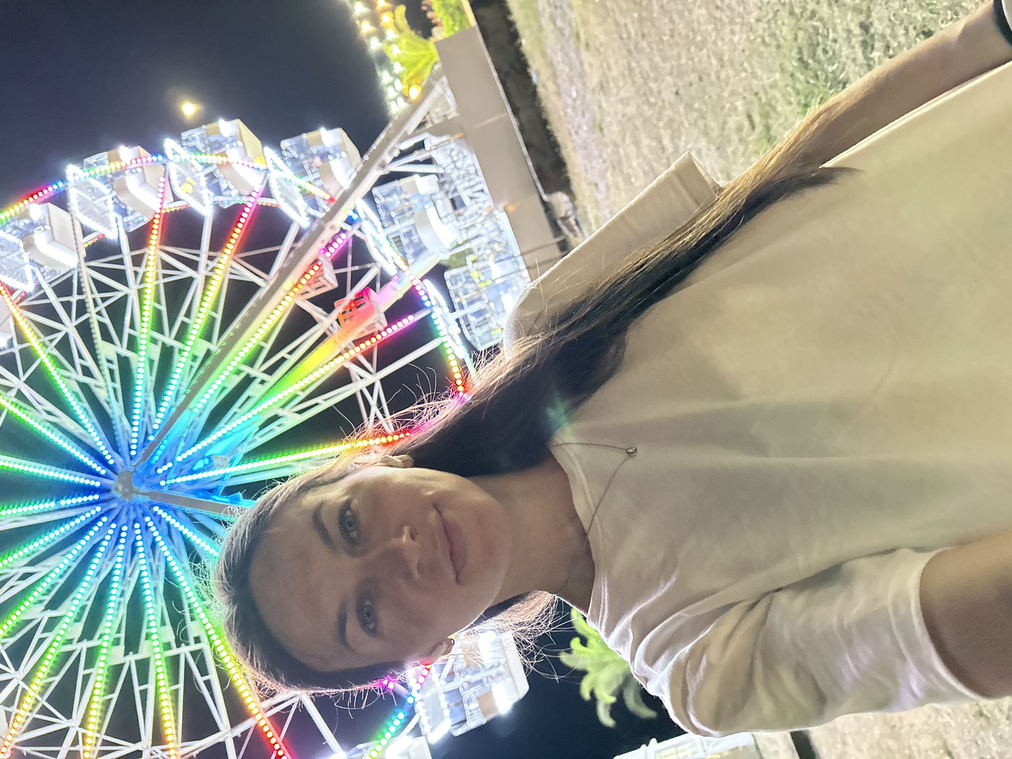 Ferris wheel lights and nightlife along Budva's waterfront strip