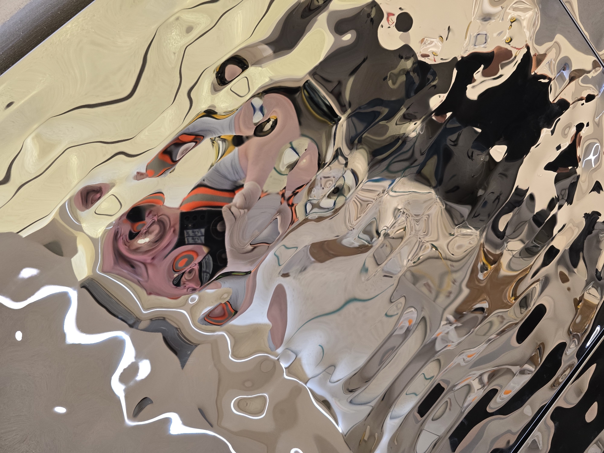Abstract reflections captured on distorted metallic surface in Jordan
