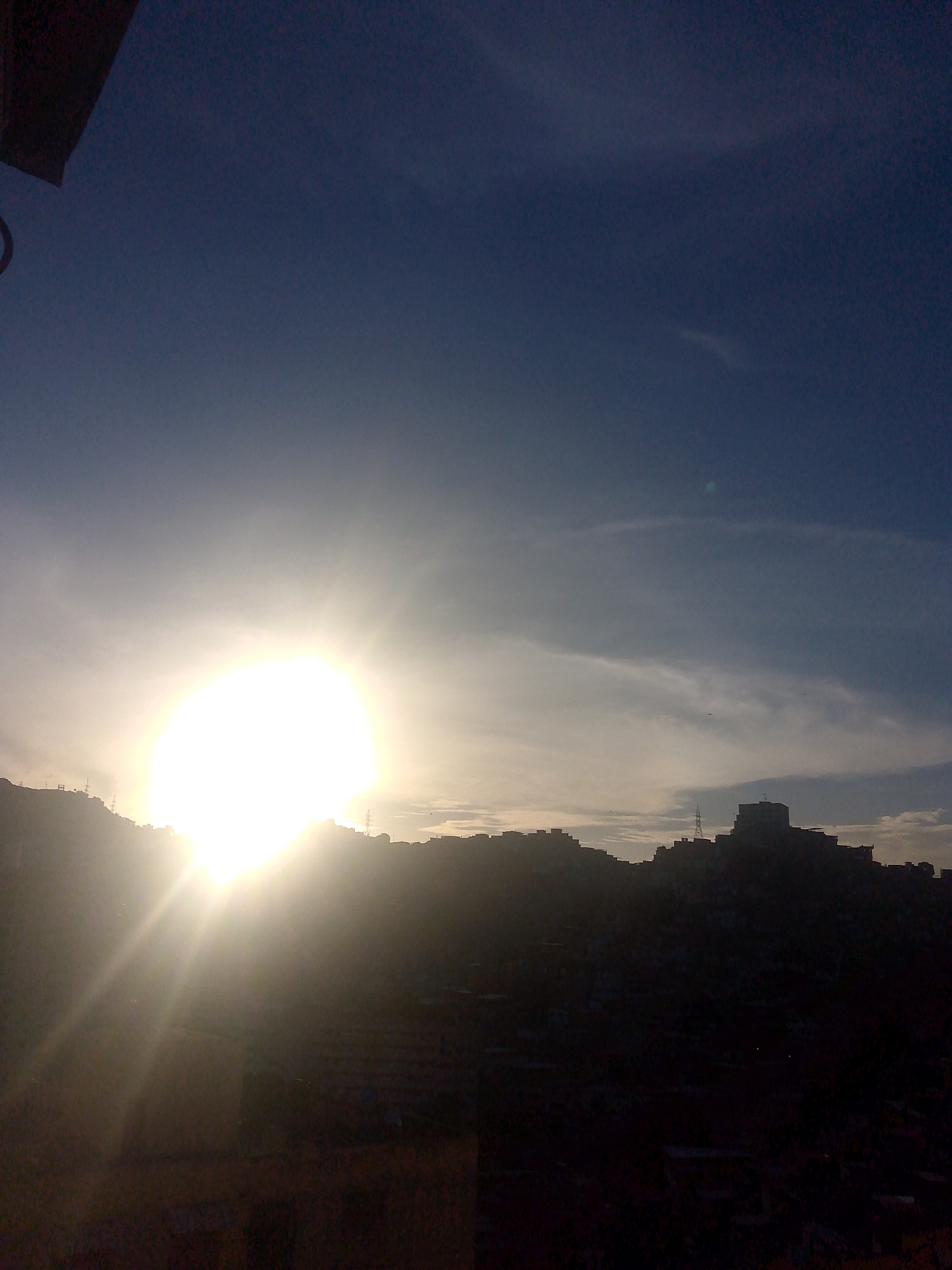 Caracas hillside neighborhoods glow during a hazy sunset