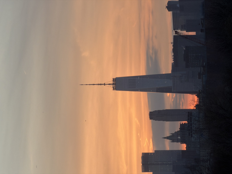 NYC skyline observed during sunset transition to nighttime illumination