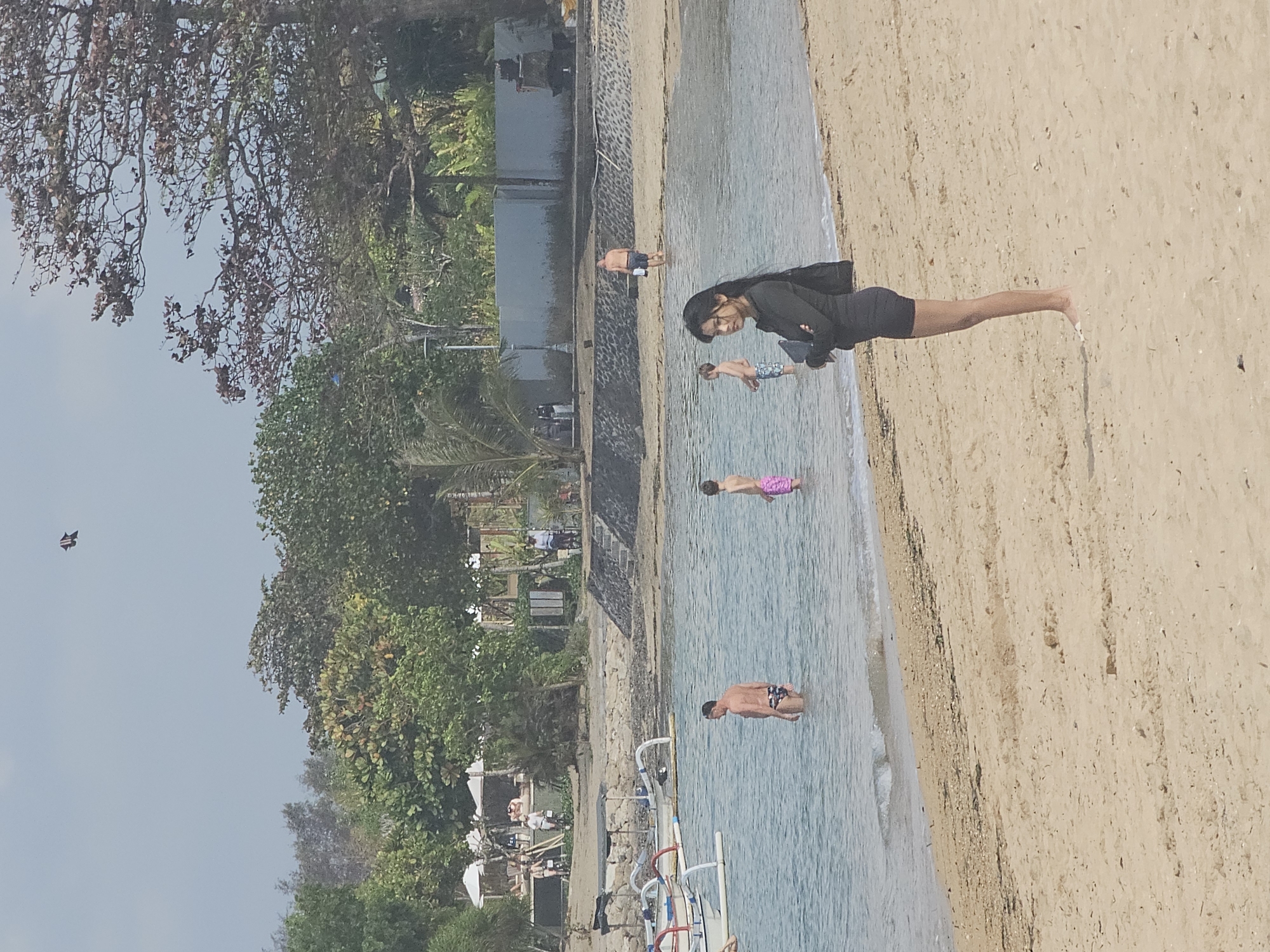 Busy Denpasar beach with boats anchored just offshore