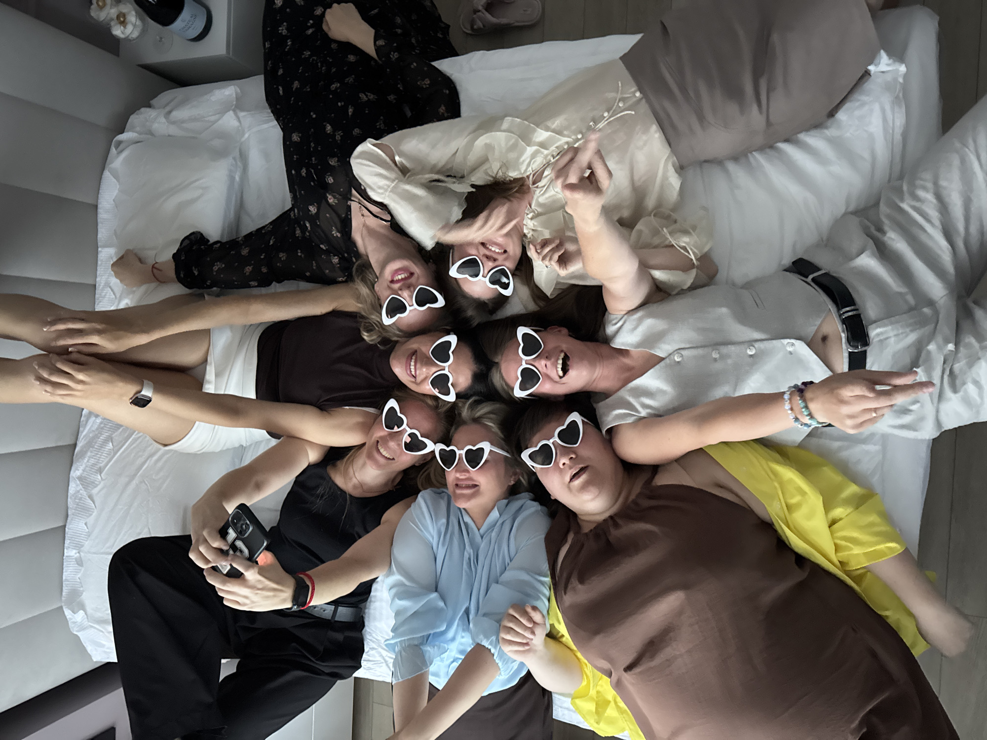 Seven women take group photo wearing heart sunglasses in Dzerzhinsk