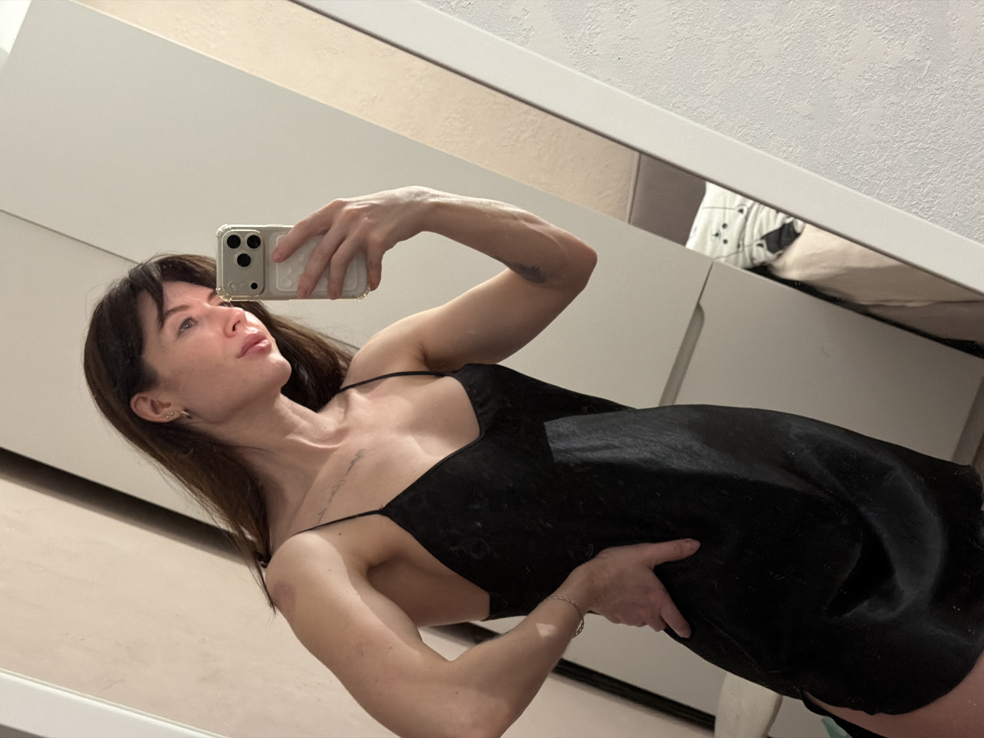 Woman takes mirror selfies in black dress, Perm