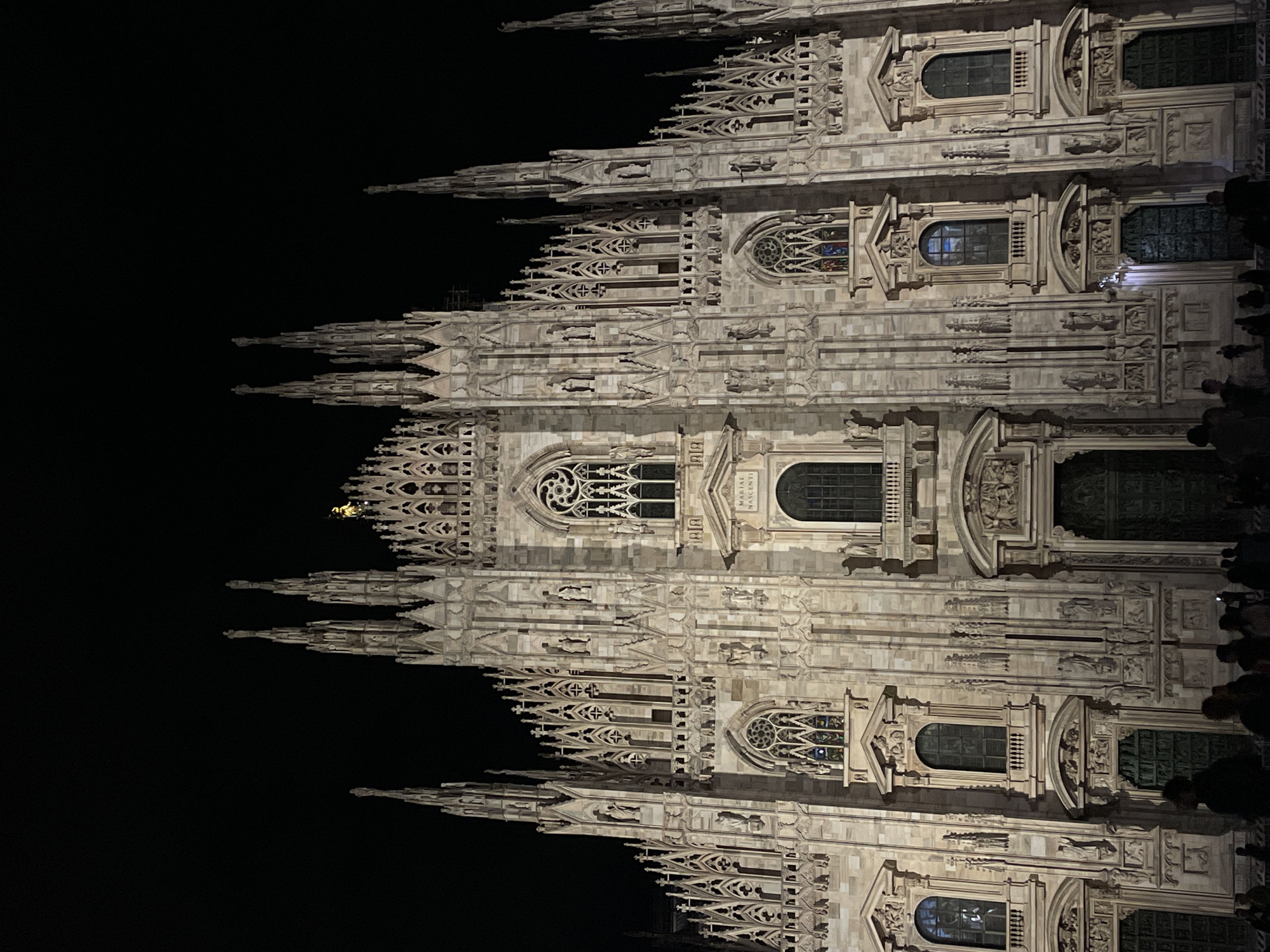 Evening crowds gather around illuminated Milan cathedral and gallery
