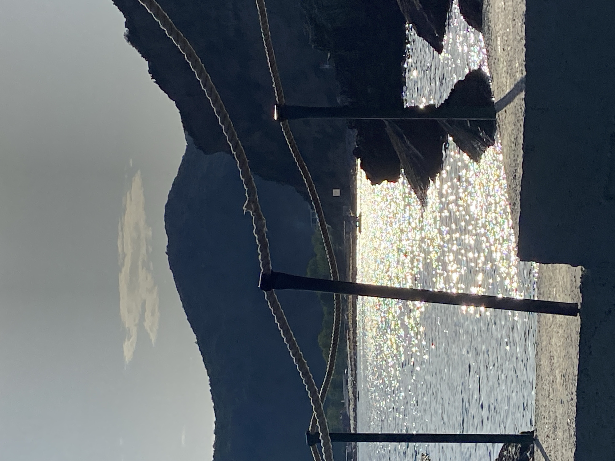Sunlit Adriatic shoreline from a concrete pier in Montenegro