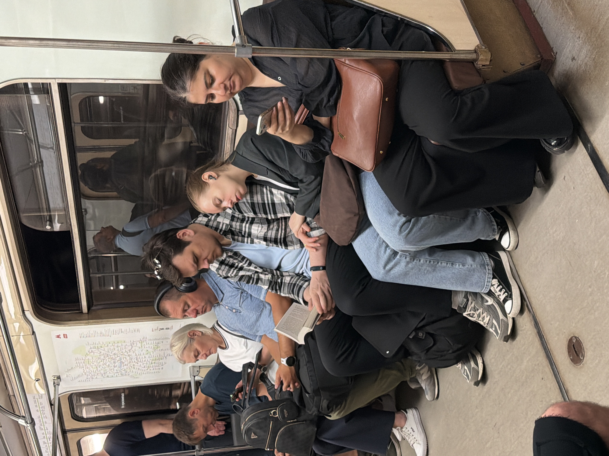 Passengers on the Moscow Metro, phones out, mid-ride.