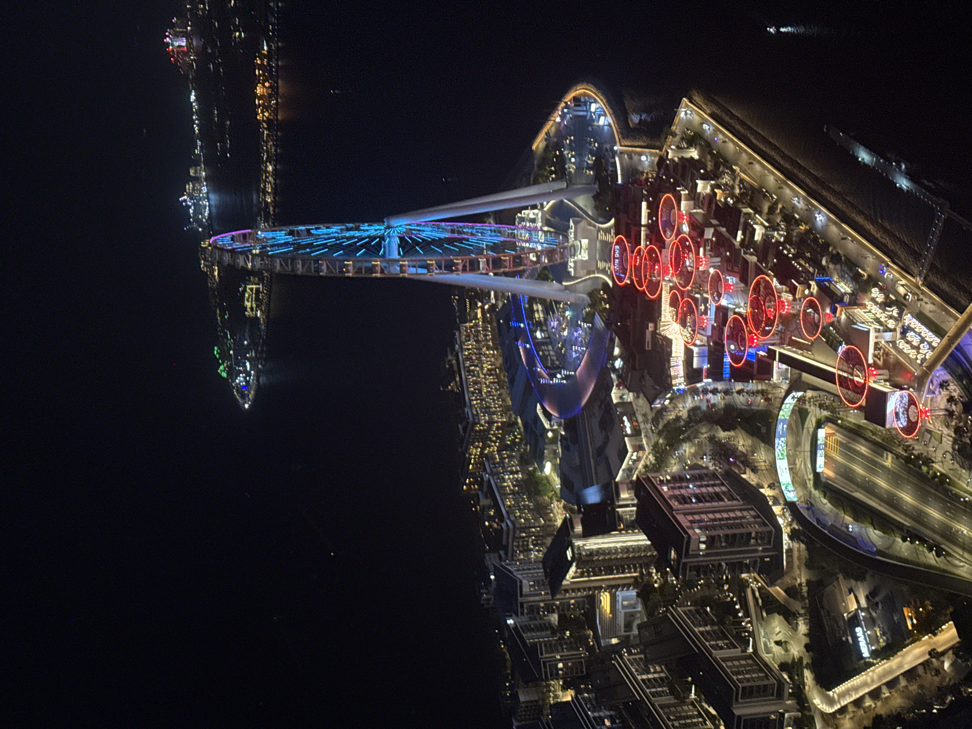 Aerial night footage captures illuminated Dubai cityscape by water
