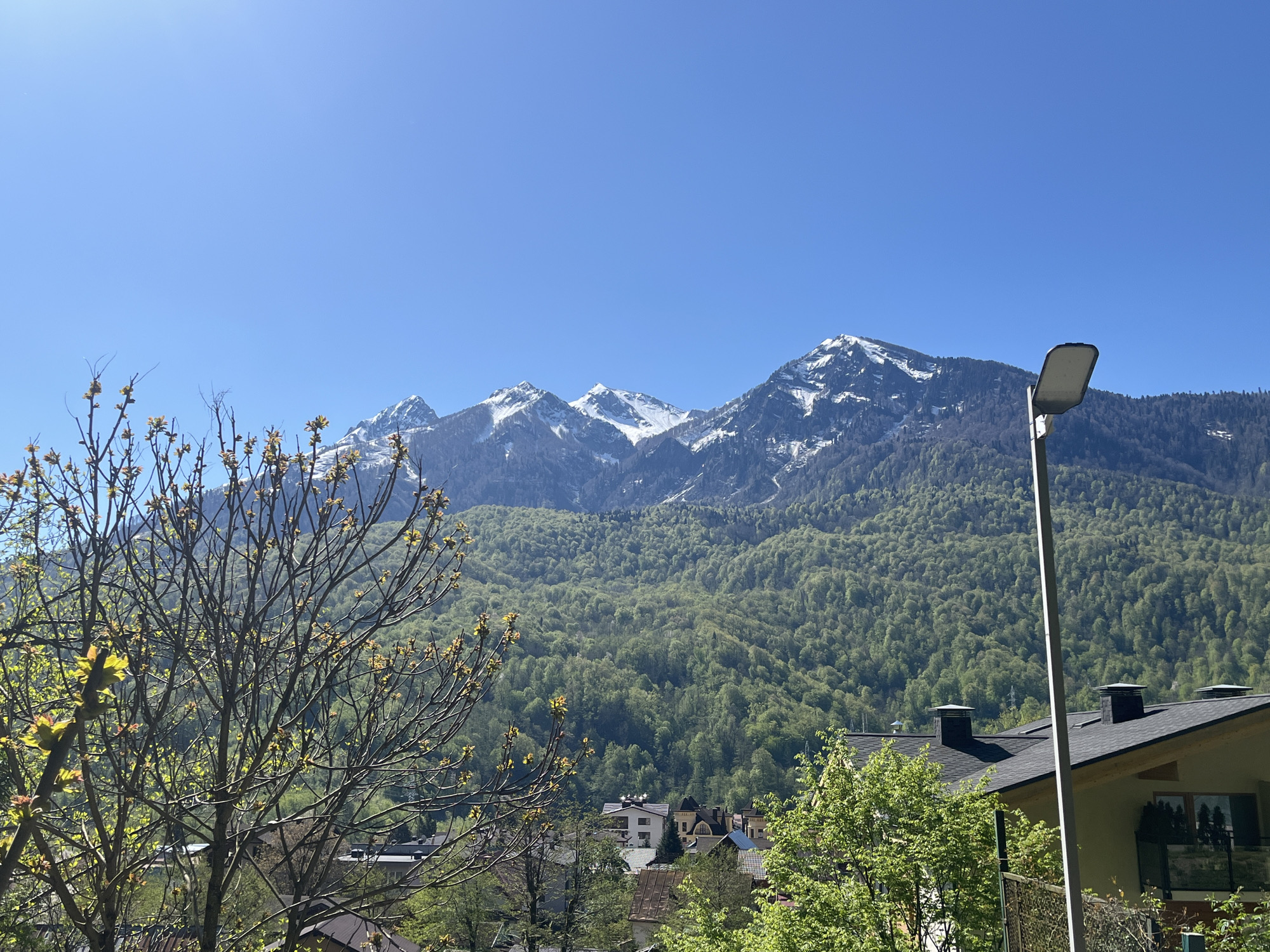 Mountain landscape with snow-capped peaks observed over residential area