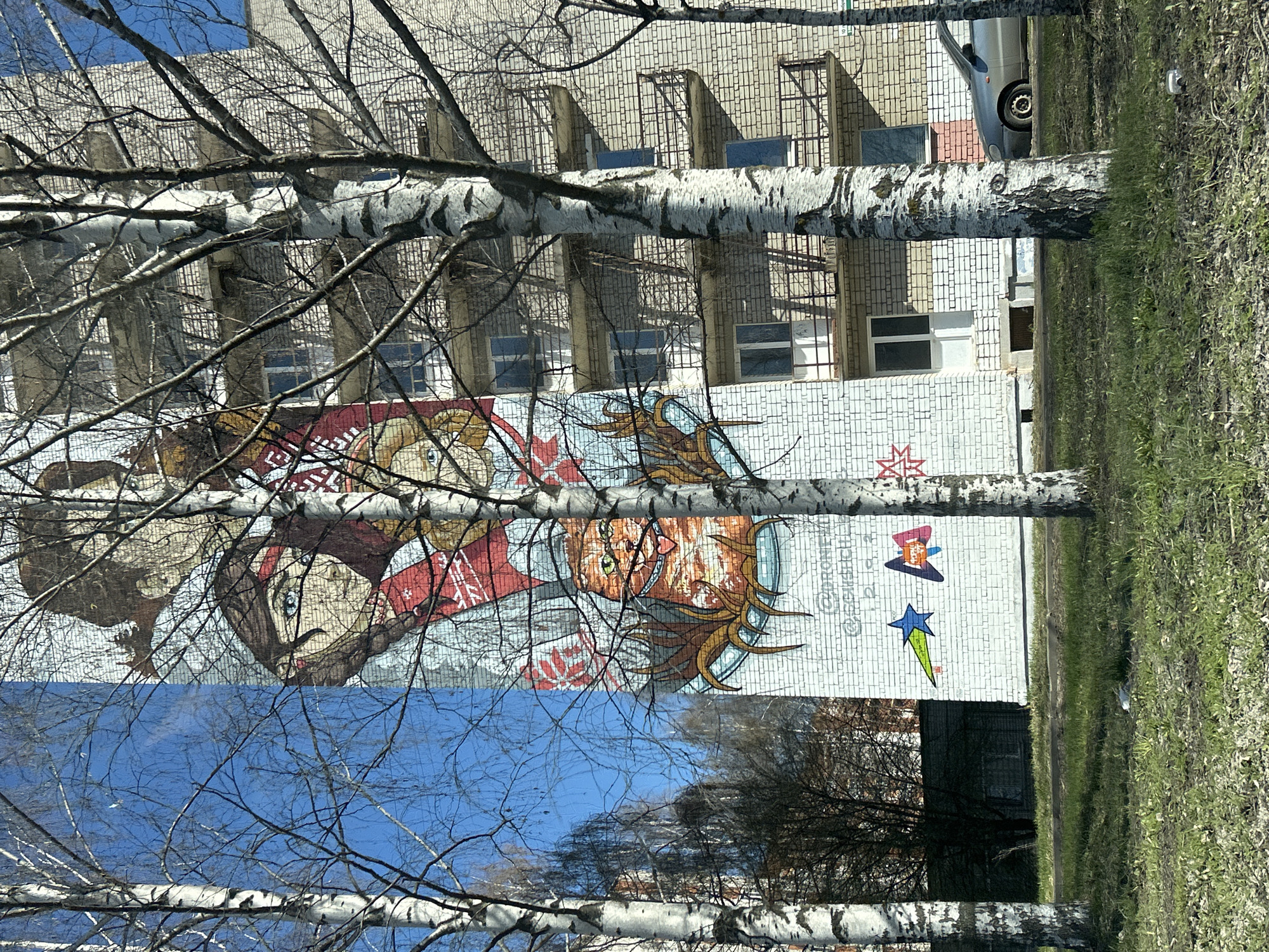 Colorful mural photographed through birch trees in Izhevsk, Russia