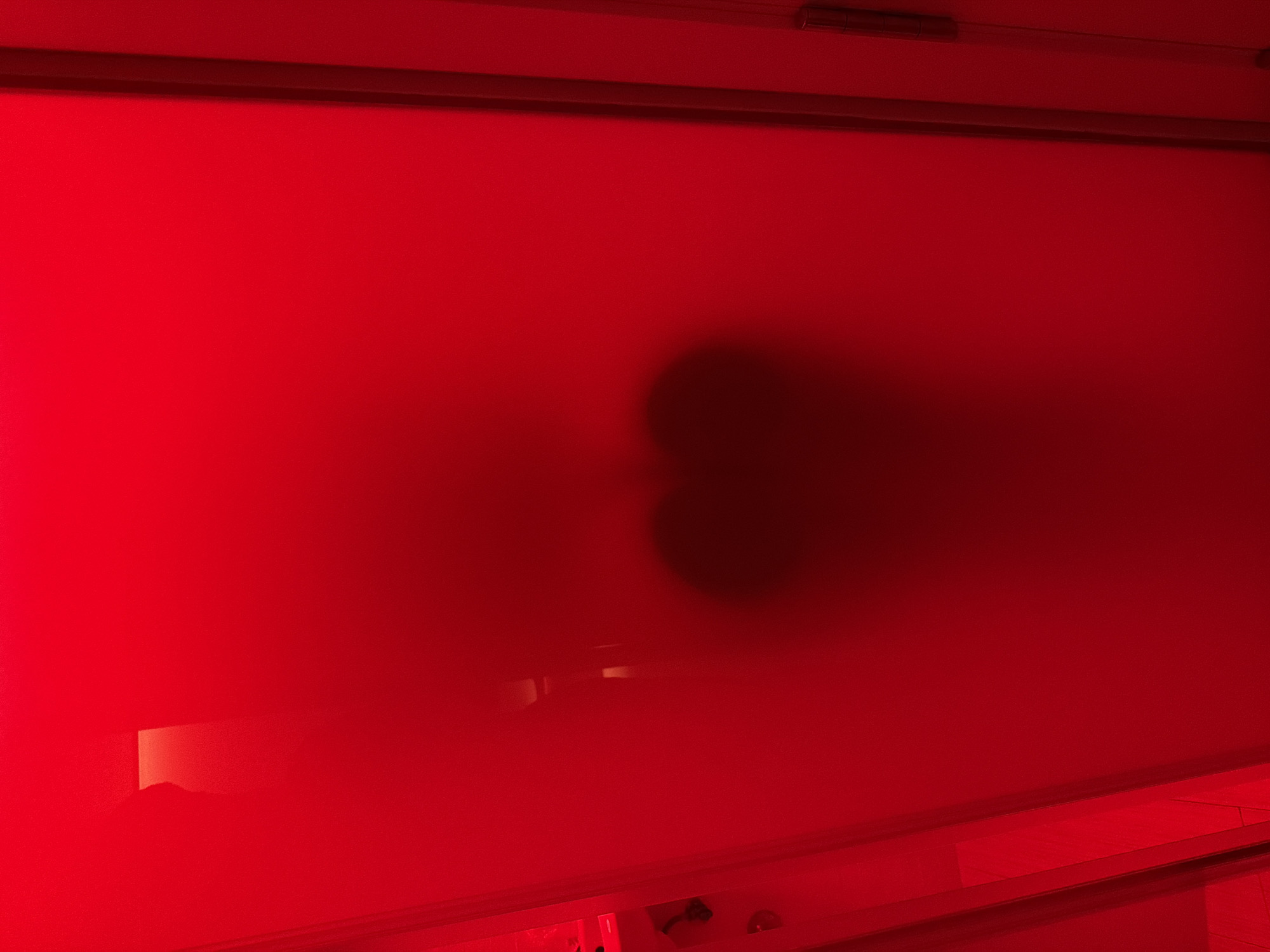 Red glass, shadows, and nighttime Madrid streets