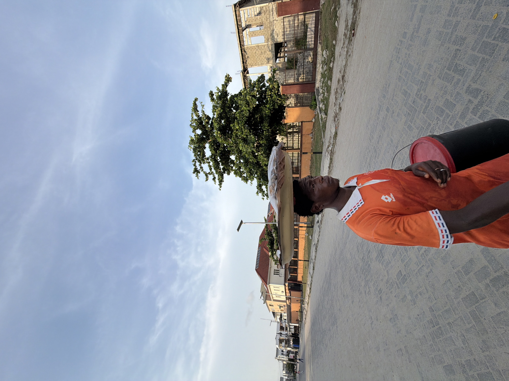 Man carries containers on head through Igboefon street