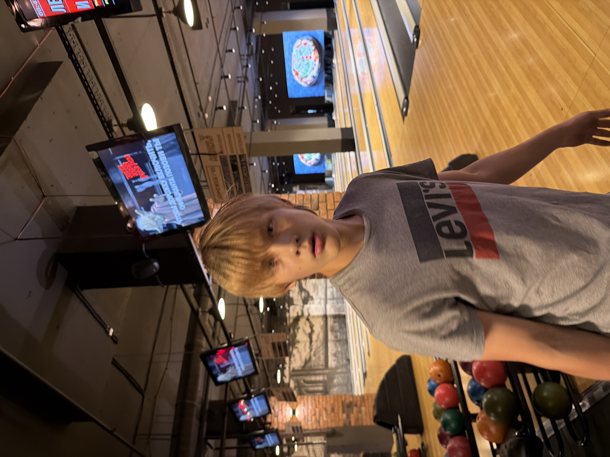 Bowling session at an Izhevsk alley, red ball mid-throw