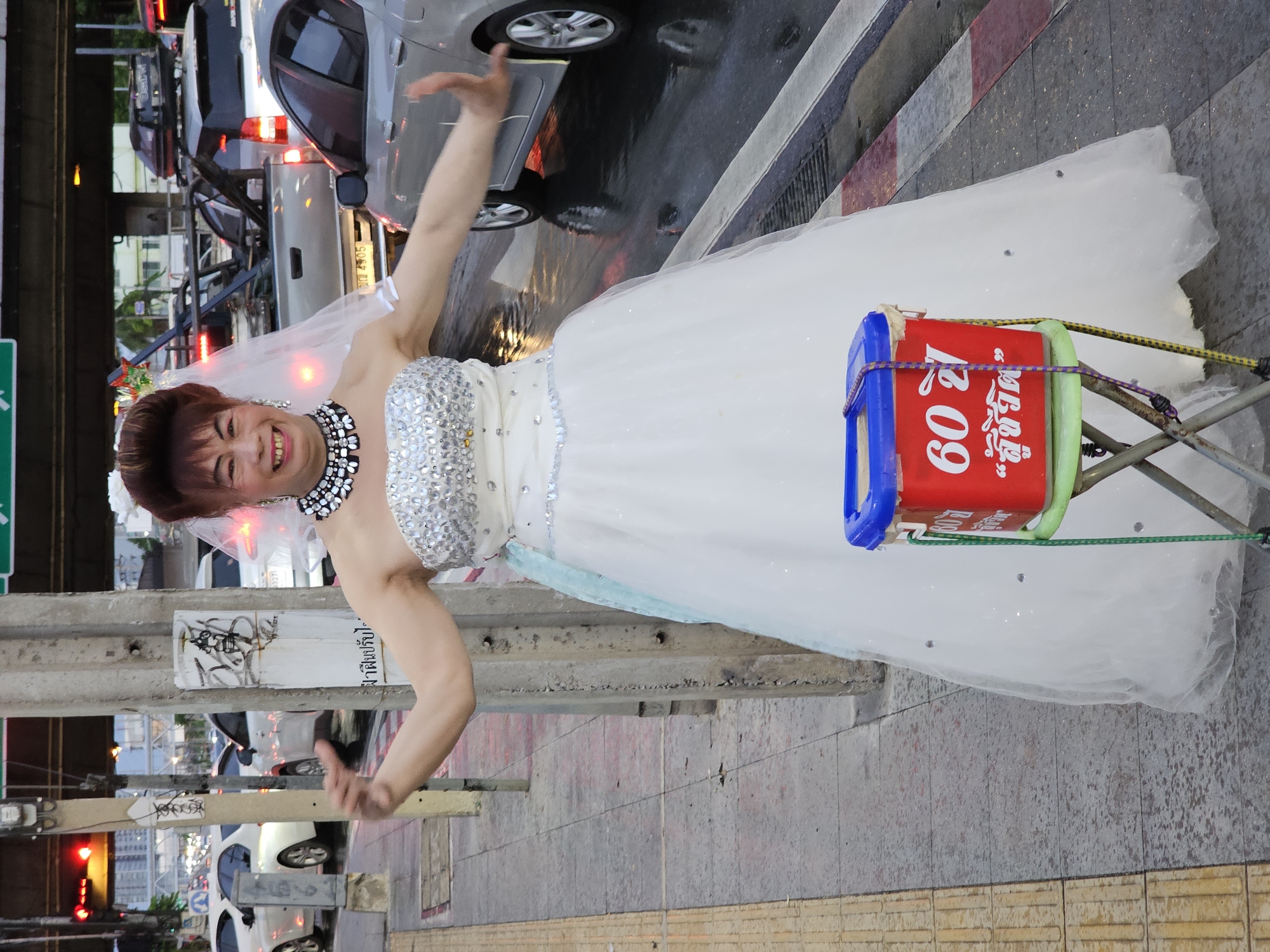 Wedding gown on a Bangkok sidewalk, arms wide open