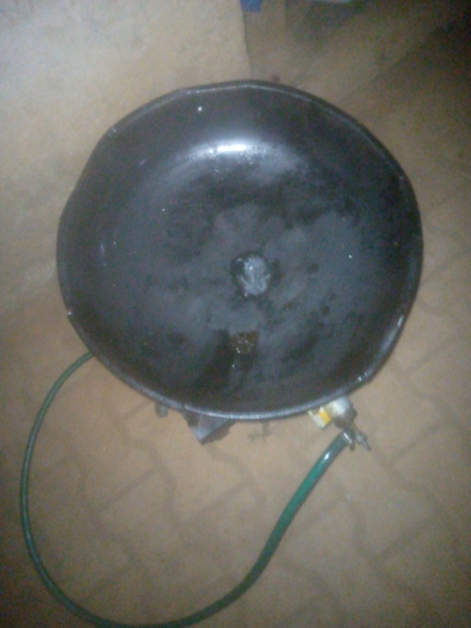 Black bowl with green hose documented containing liquid residue