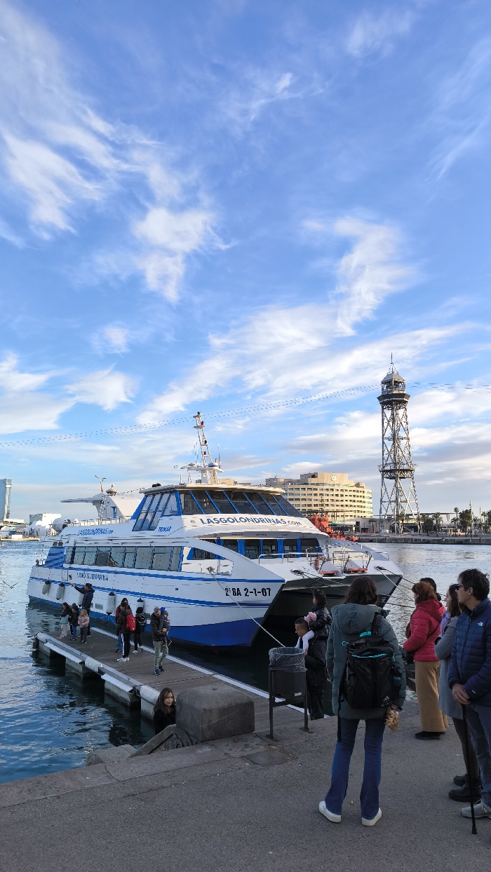 Barcelona waterfront buzzes with tourists, street performers, monument visitors