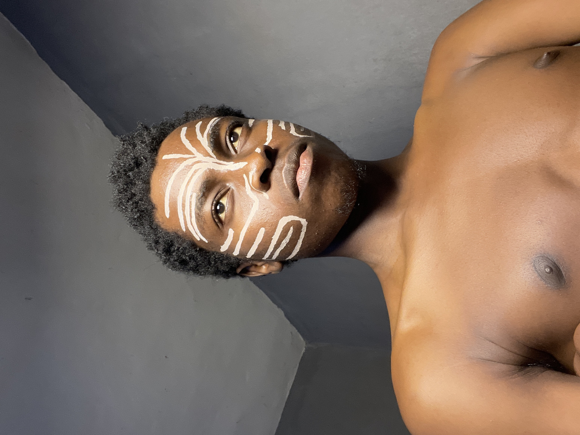 Nigerian man poses with traditional face paint on Democracy Day