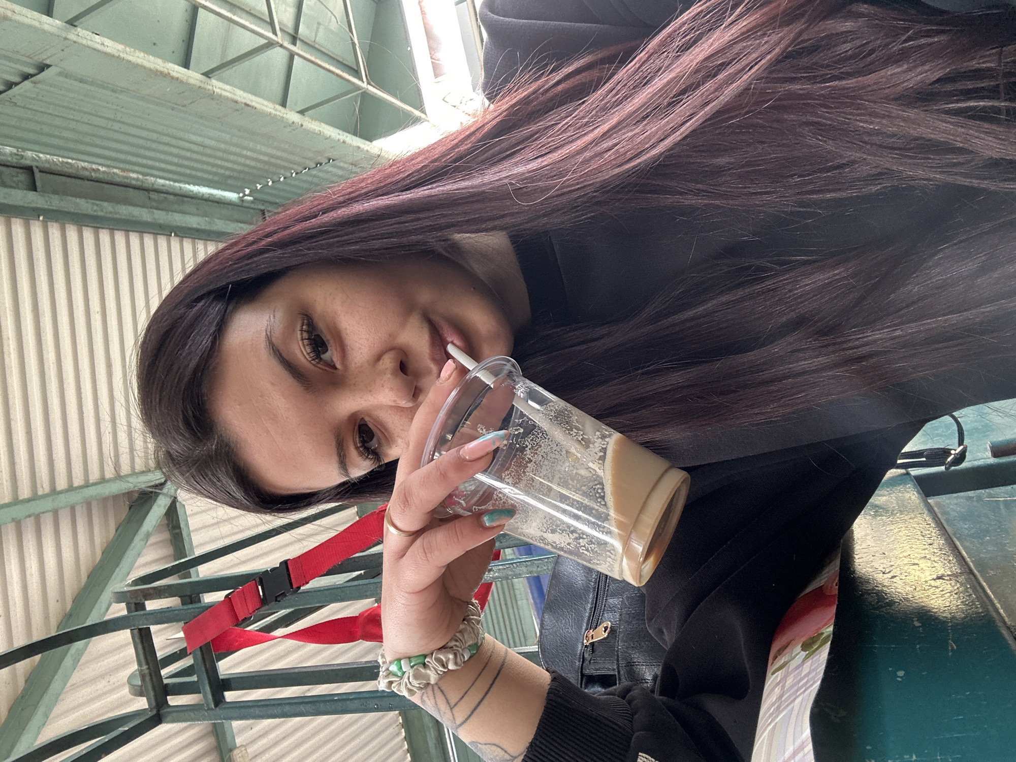 Woman drinks coffee at Sliven railway station early morning