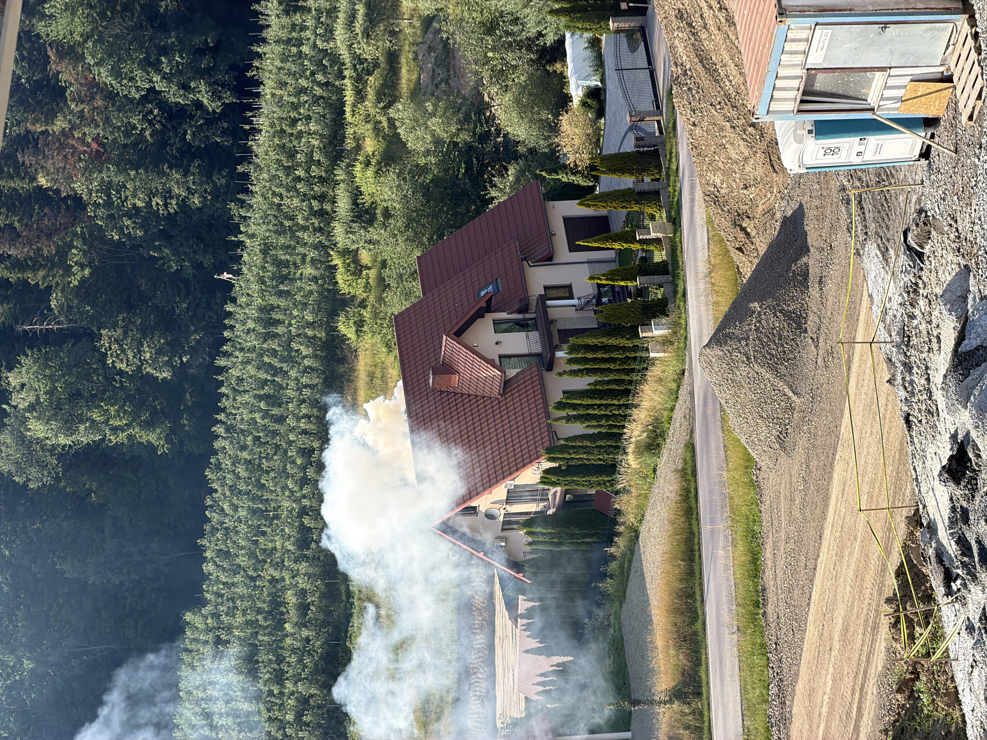 Red-roofed house nestled among trees in rural Stróża, Poland