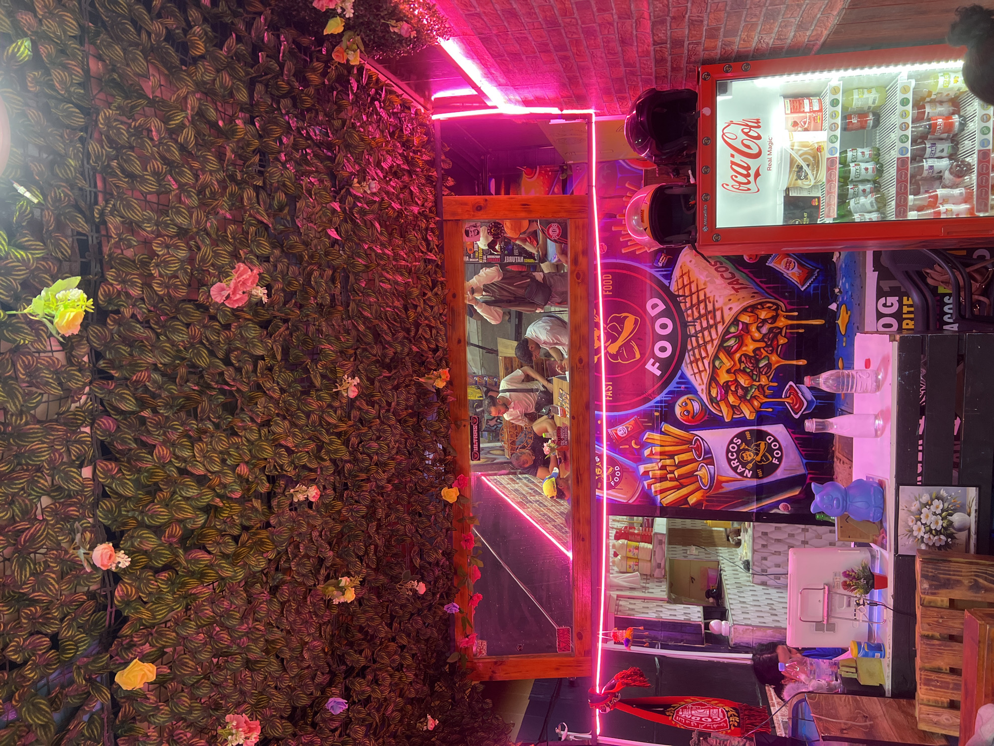 Food vendor in Dkhissa features pink neon, artificial foliage decor
