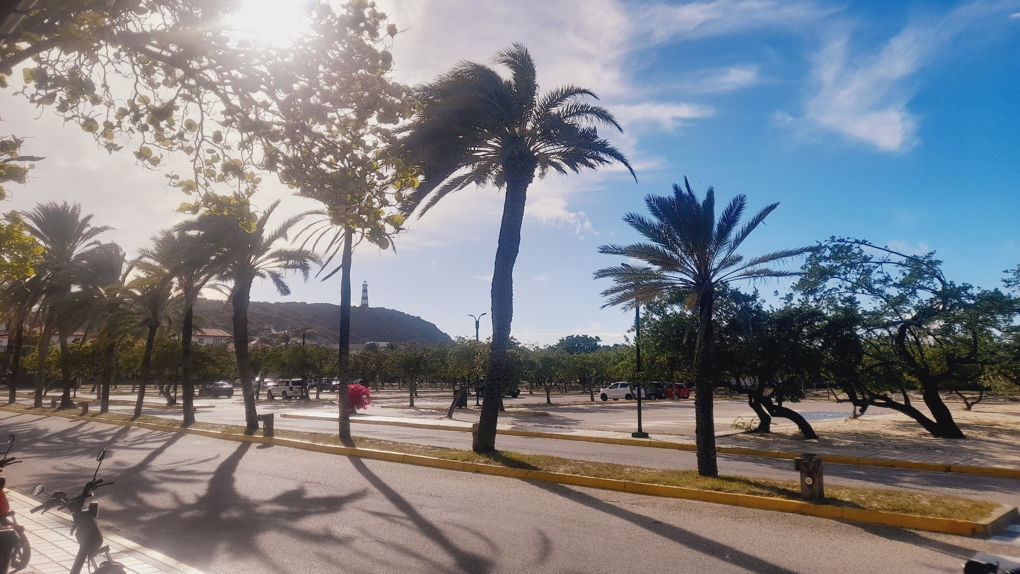 Pedro González waterfront at golden hour, scooters and lighthouse