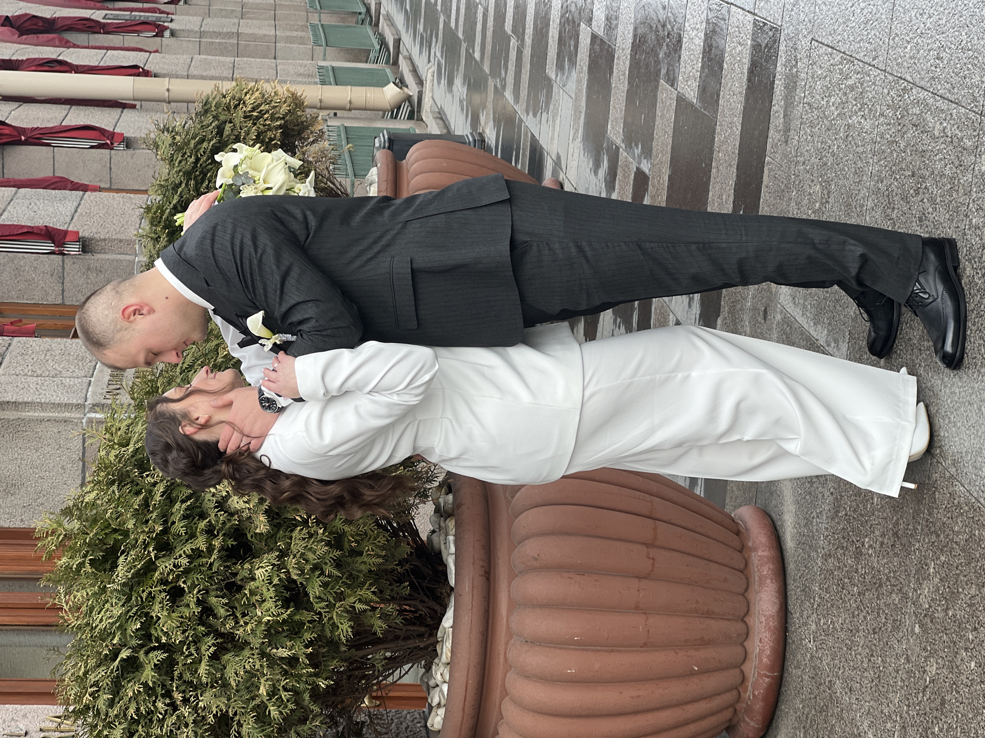 Newlyweds kiss on wet Saint Petersburg sidewalk