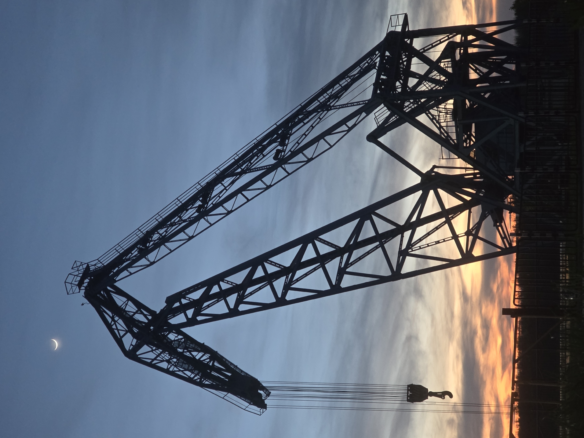 Construction crane silhouetted against evening sky in Ruse, Bulgaria