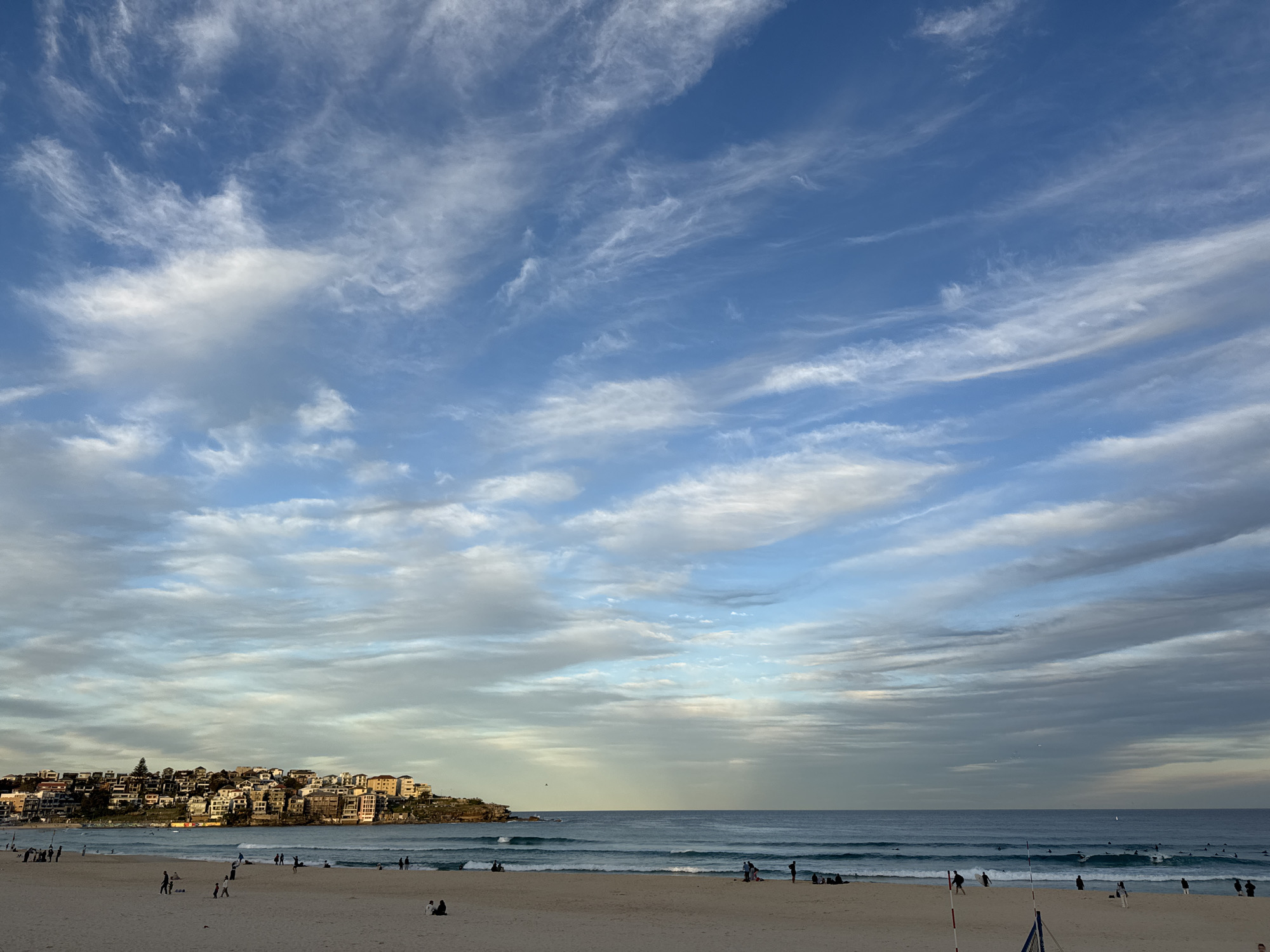 Bondi Beach under a cloud-streaked golden sky