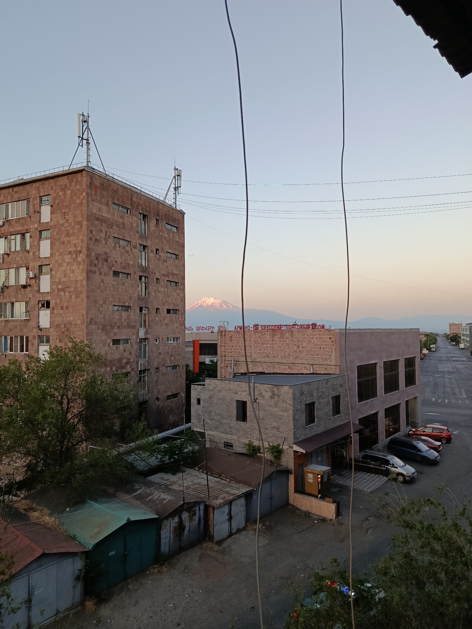 Yerevan residential streets at dawn, stone buildings and green canopy