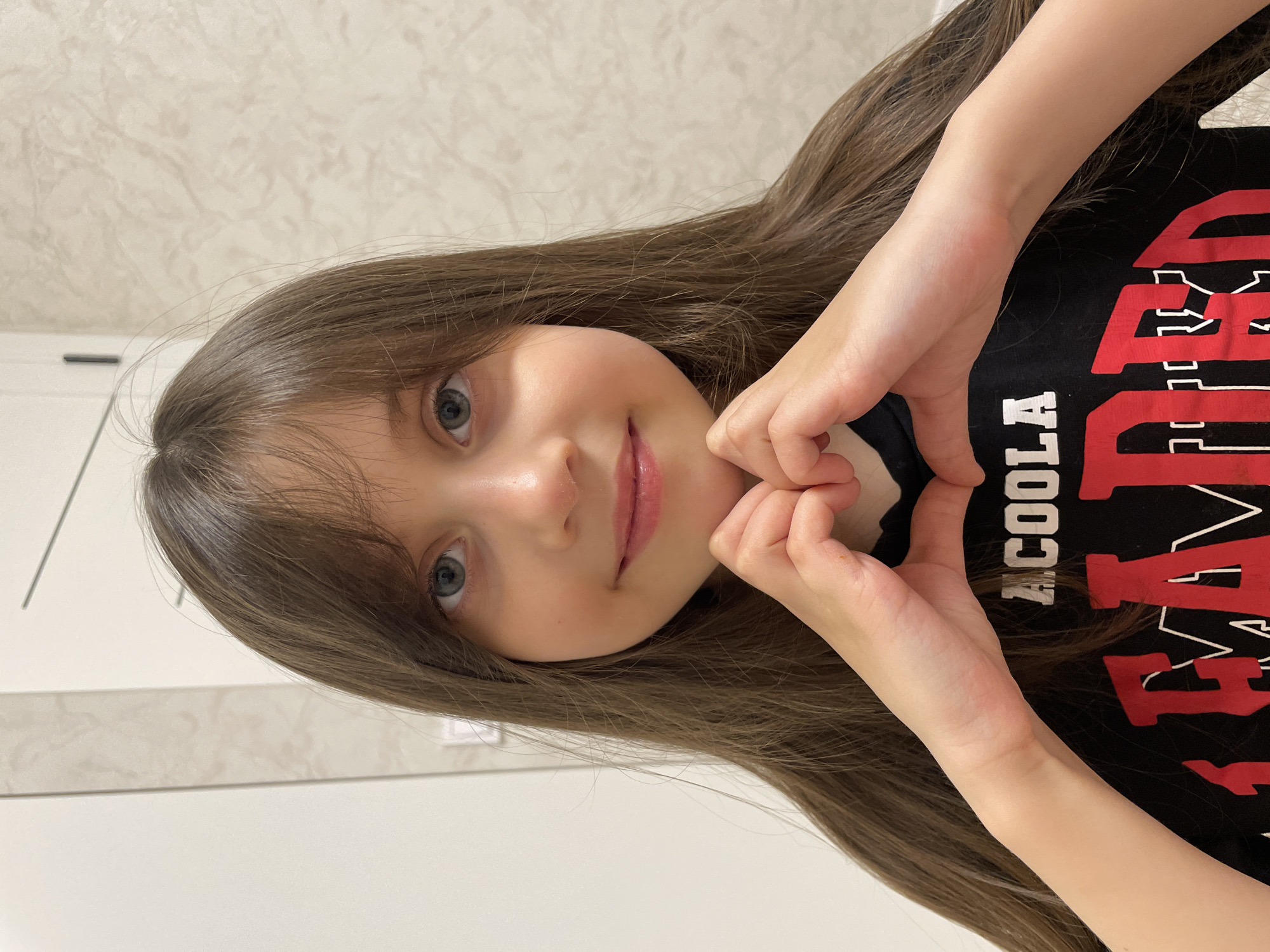 Girl poses for photo making heart gesture in Izhevsk