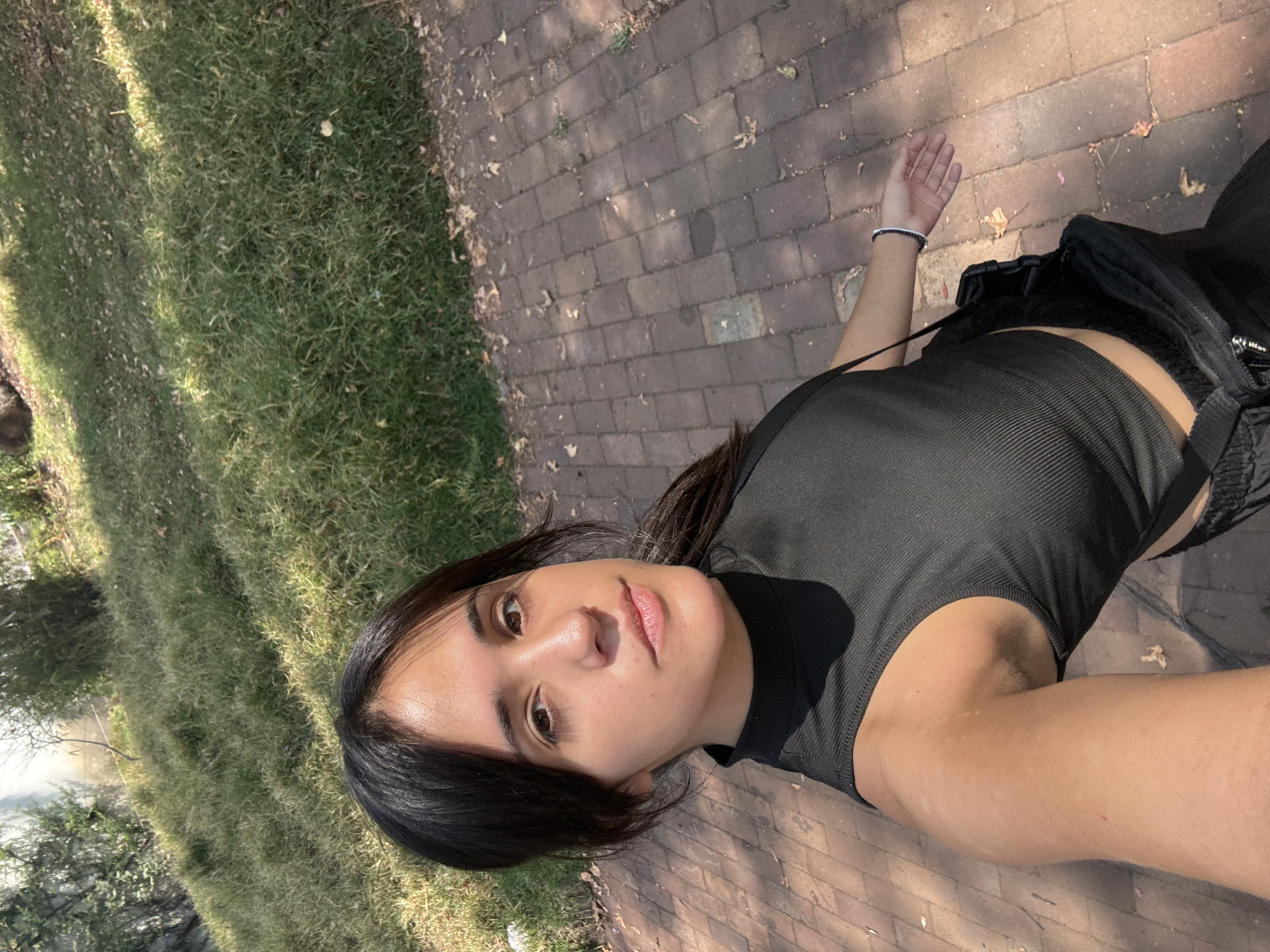 Woman takes selfie in Mexico City park on sunny afternoon
