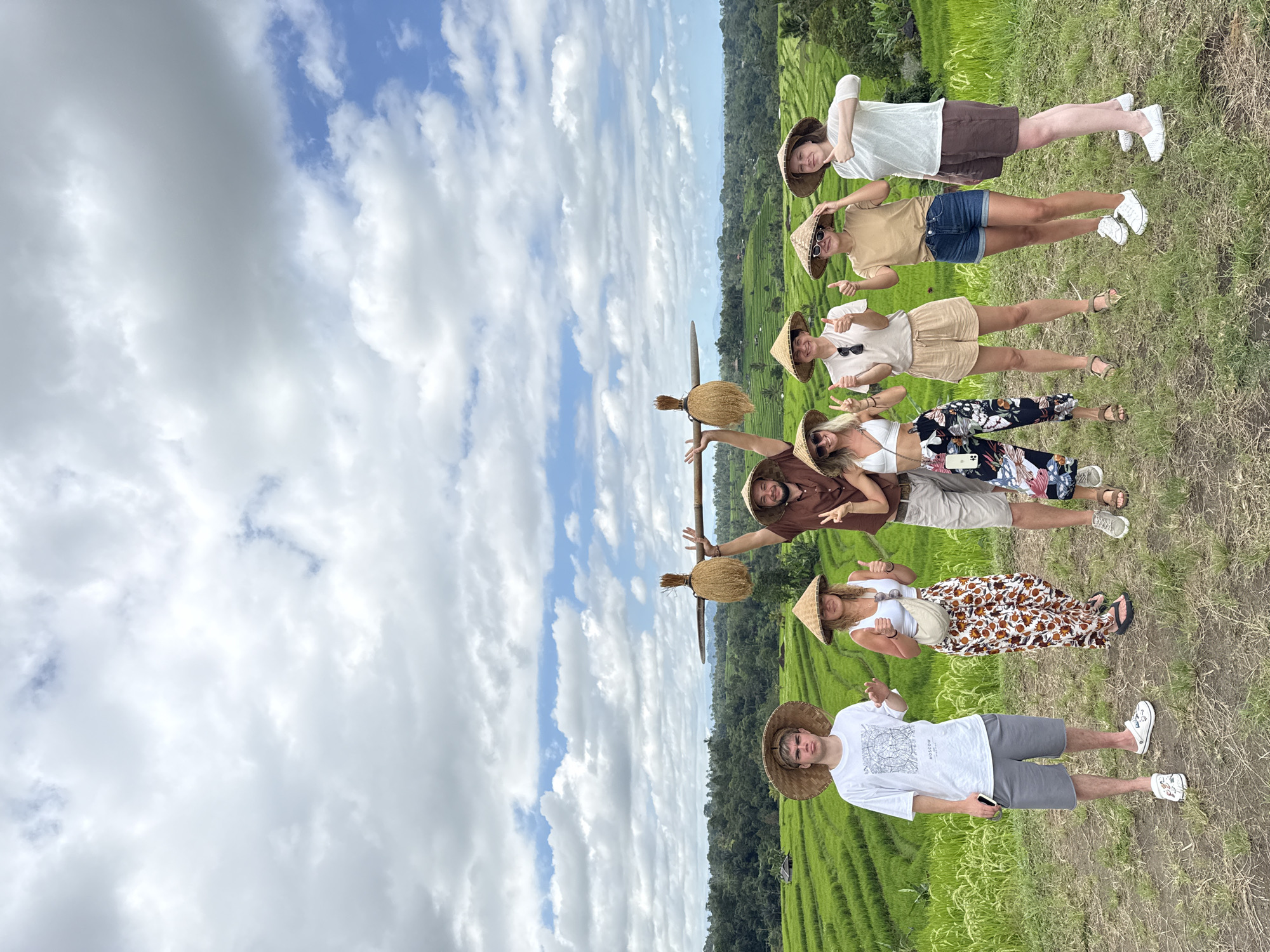 Tourist group photographed in Penebel rice terraces wearing conical hats