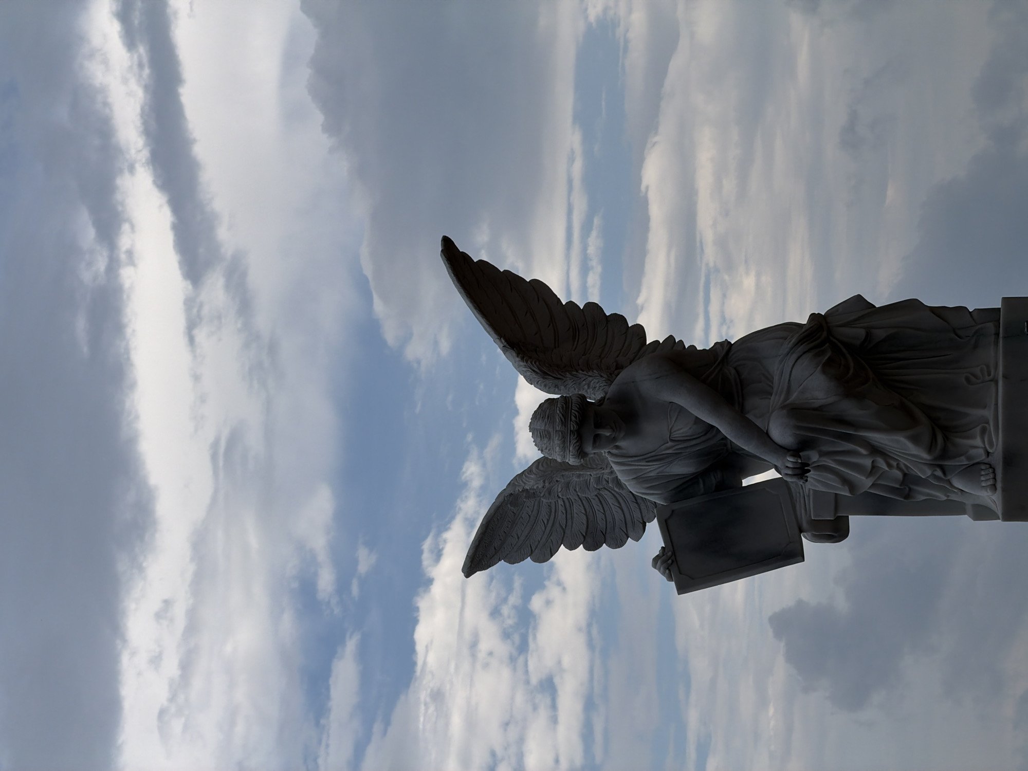 Angel statue photographed against dramatic sky in Đà Nẵng