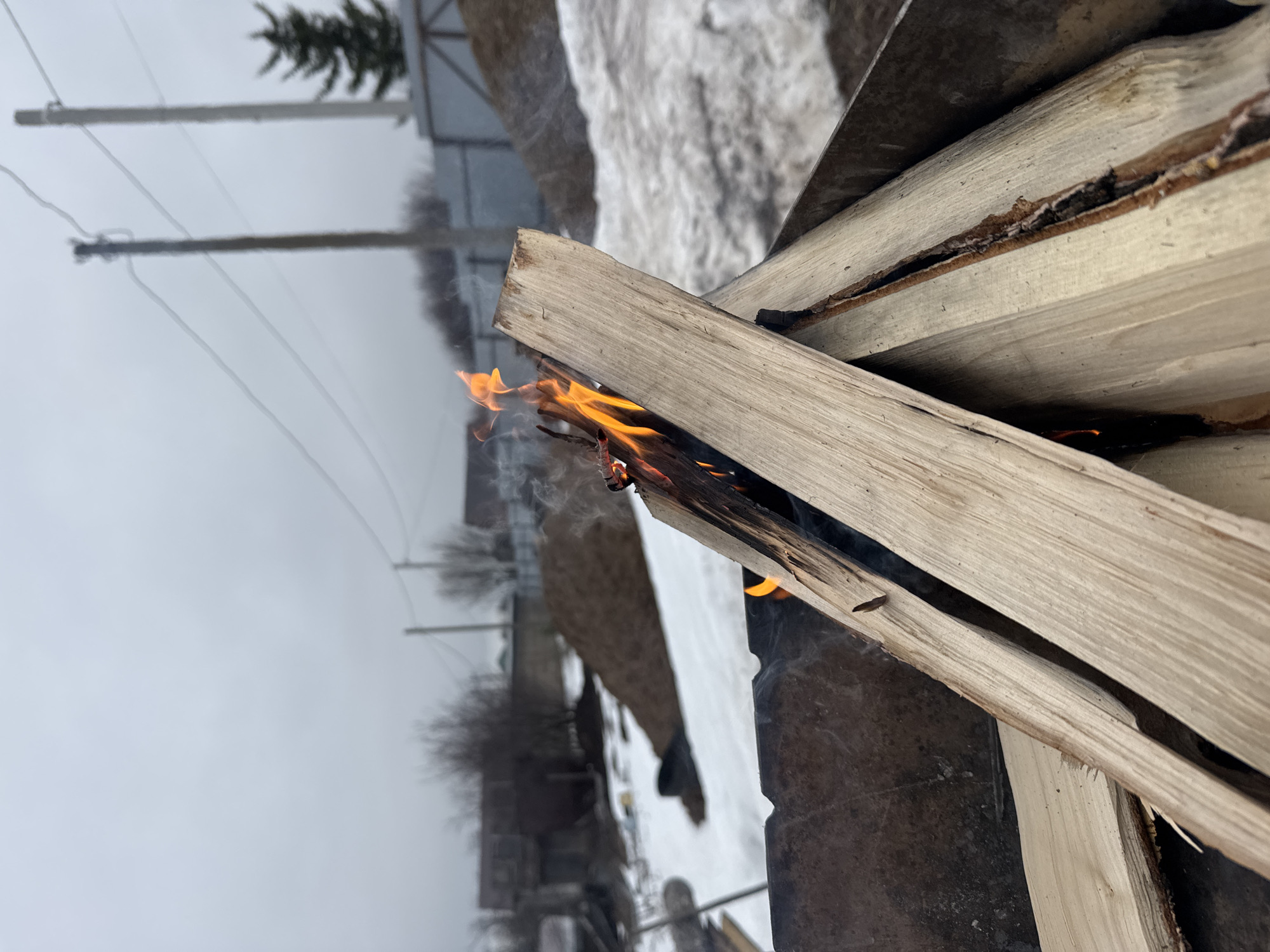 Small outdoor fire burns in metal pit in Chaikovsky